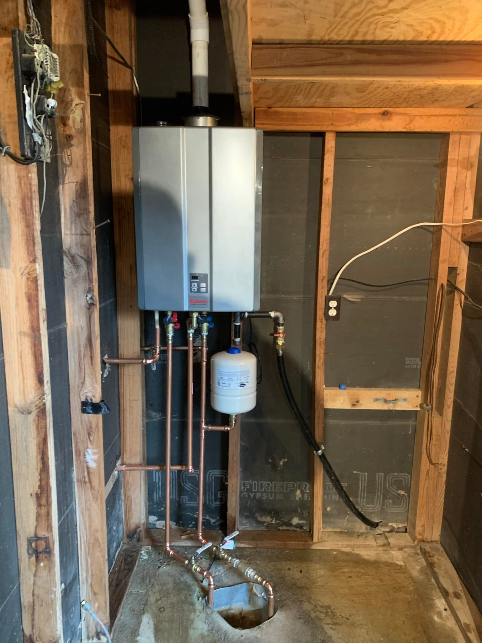A water heater is being installed in a basement.