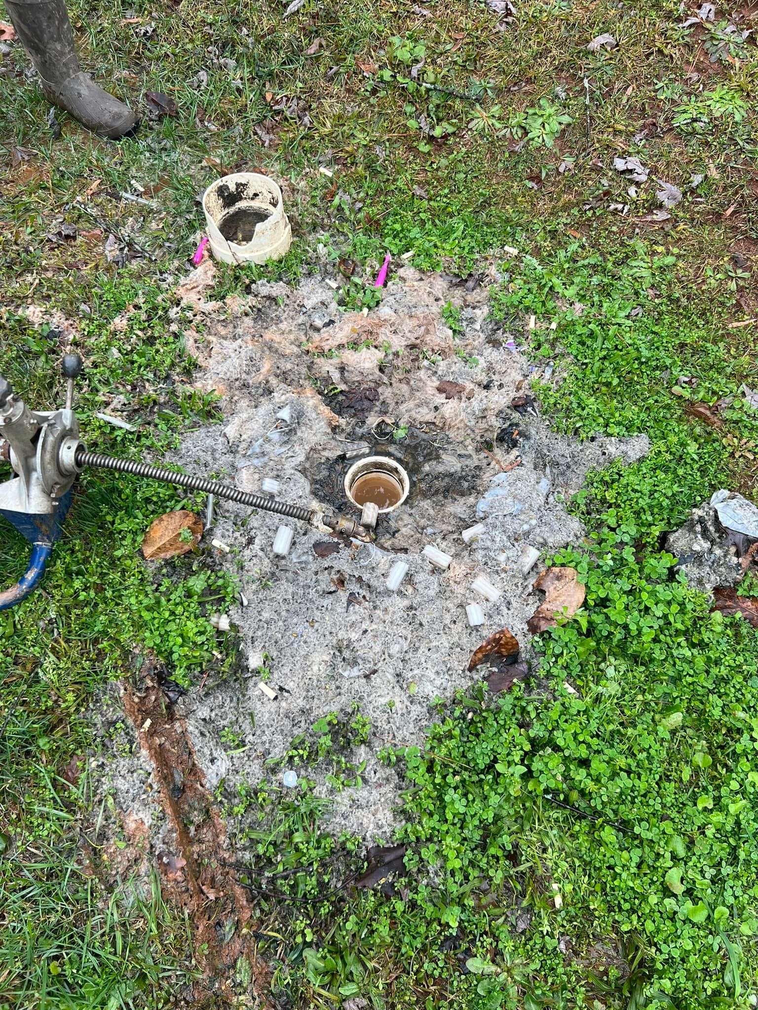 There is a hole in the ground in the grass.