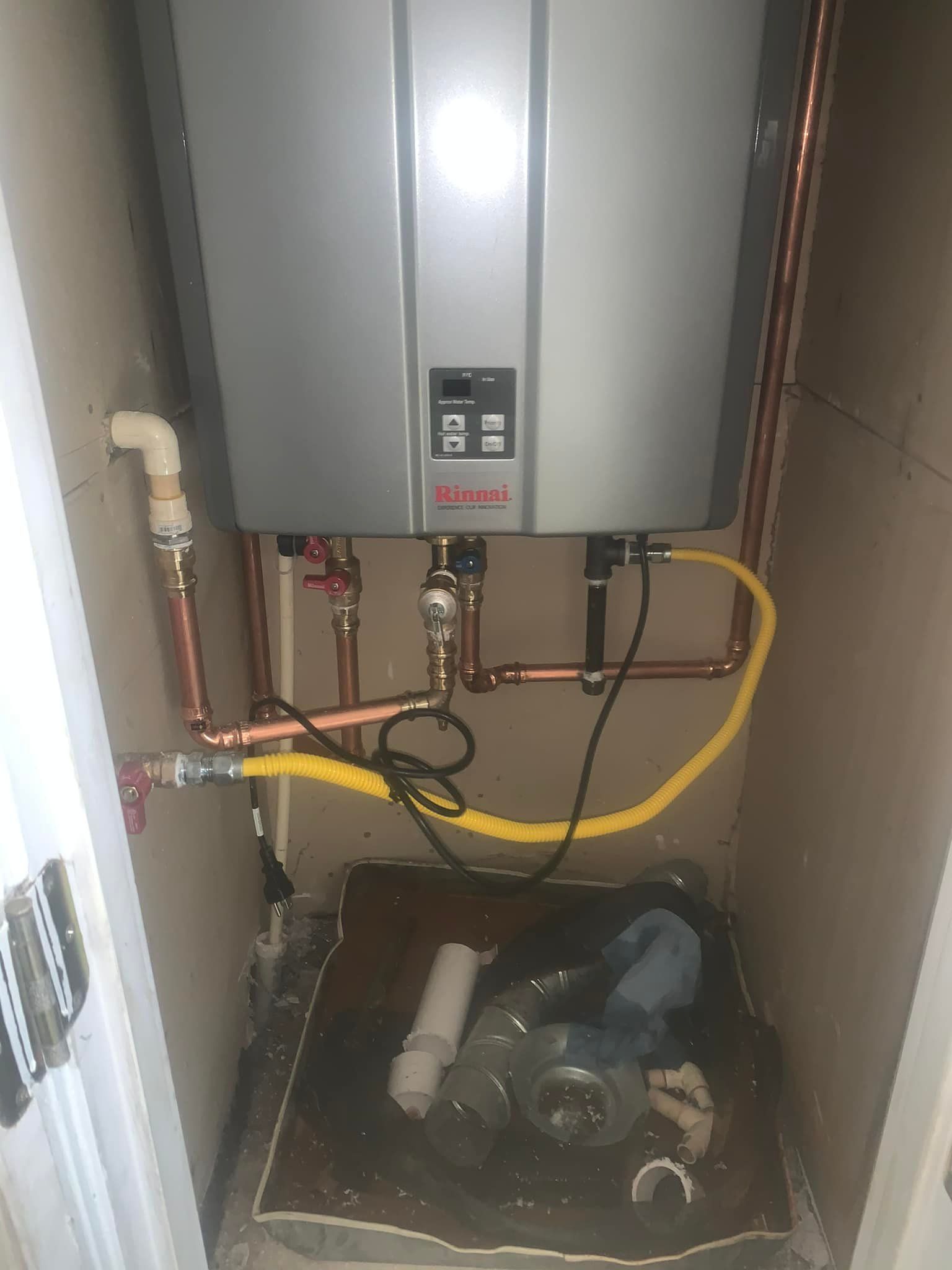 A water heater is connected to a gas line in a bathroom.