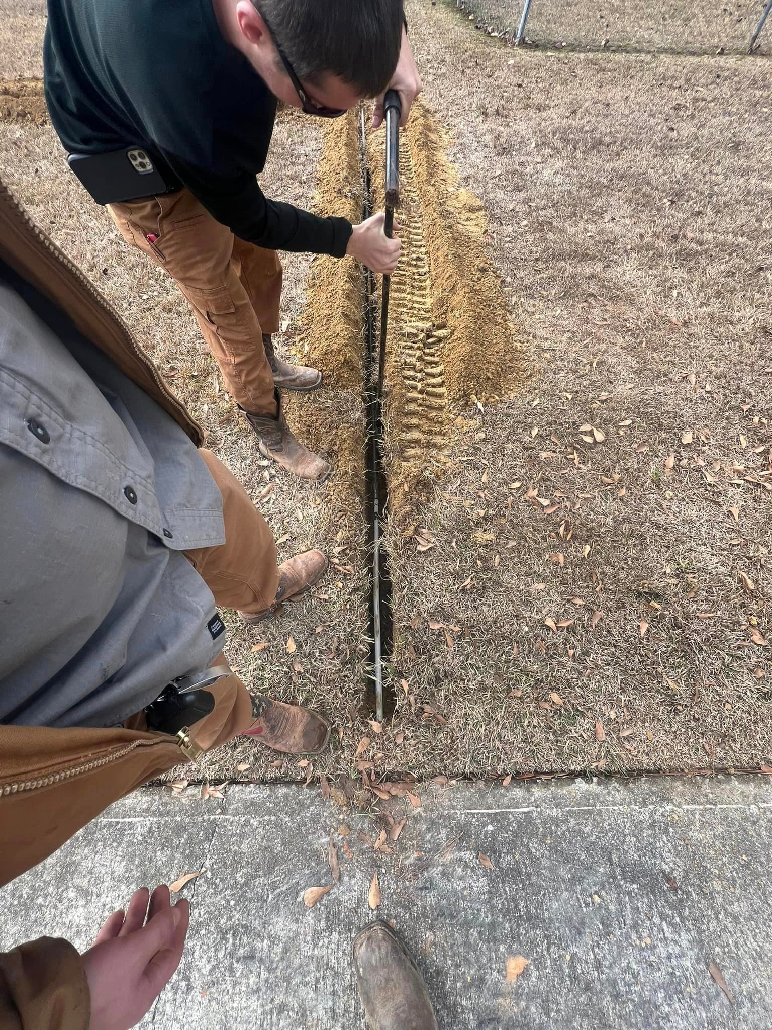 A man is sweeping the sidewalk with a broom.