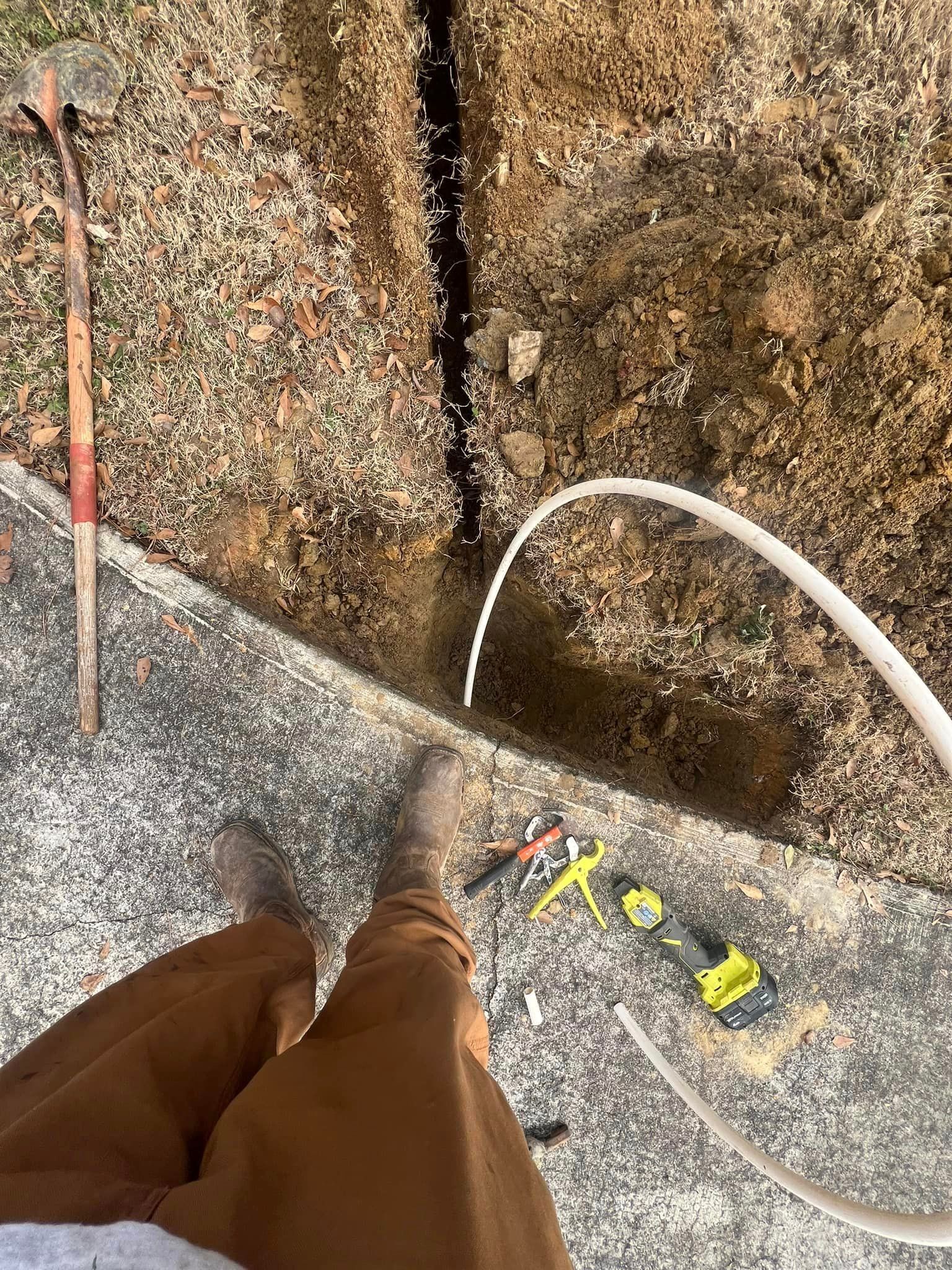 A person is standing next to a hole in the ground.