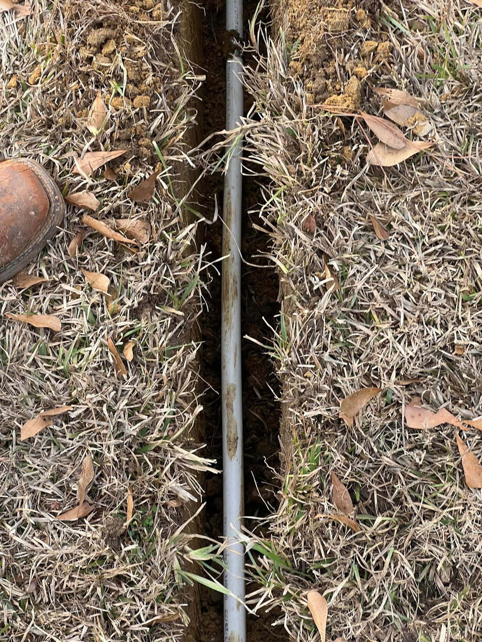A pipe is sitting in the middle of a hole in the ground.