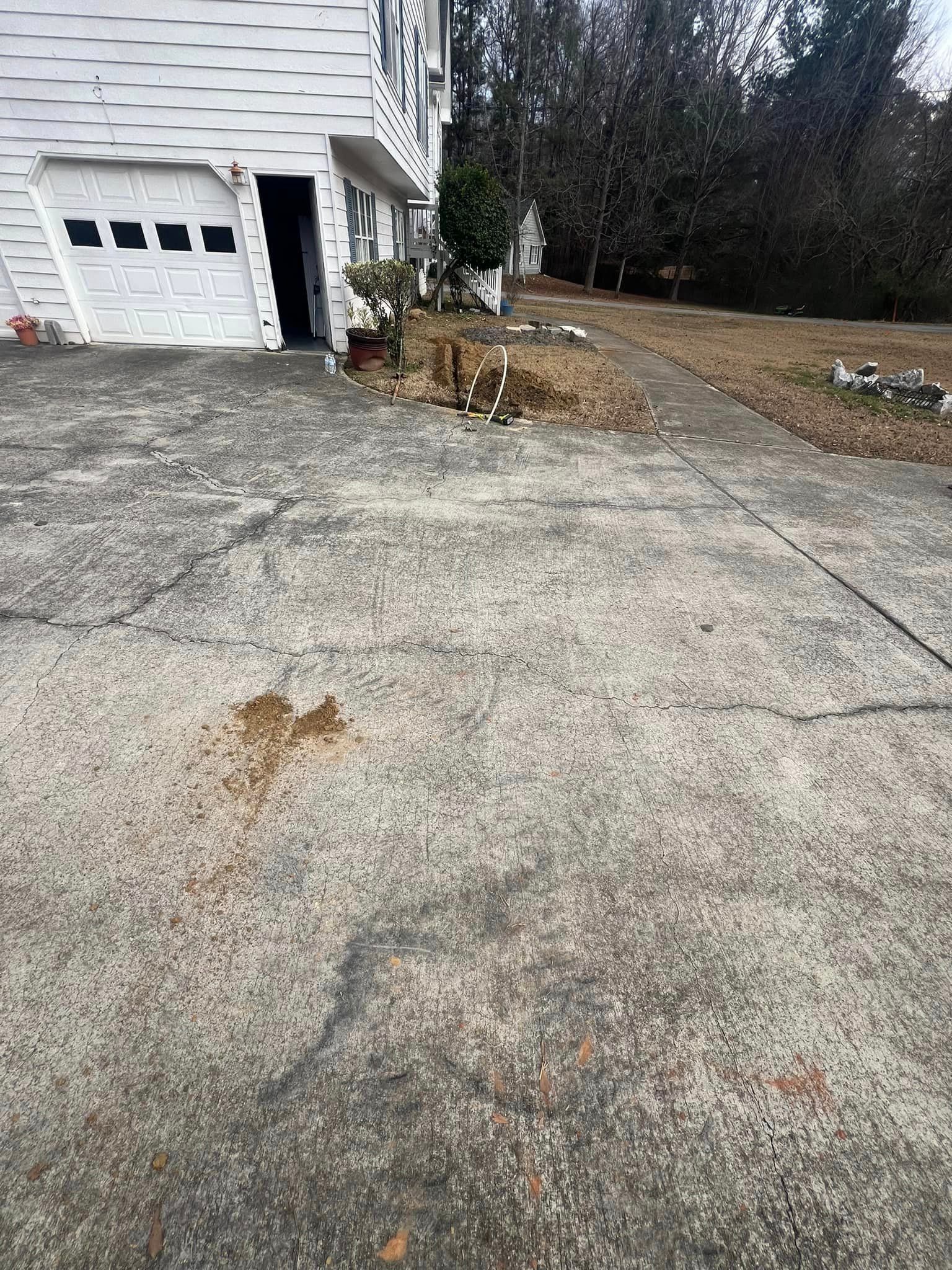 A concrete driveway in front of a house with a garage door.