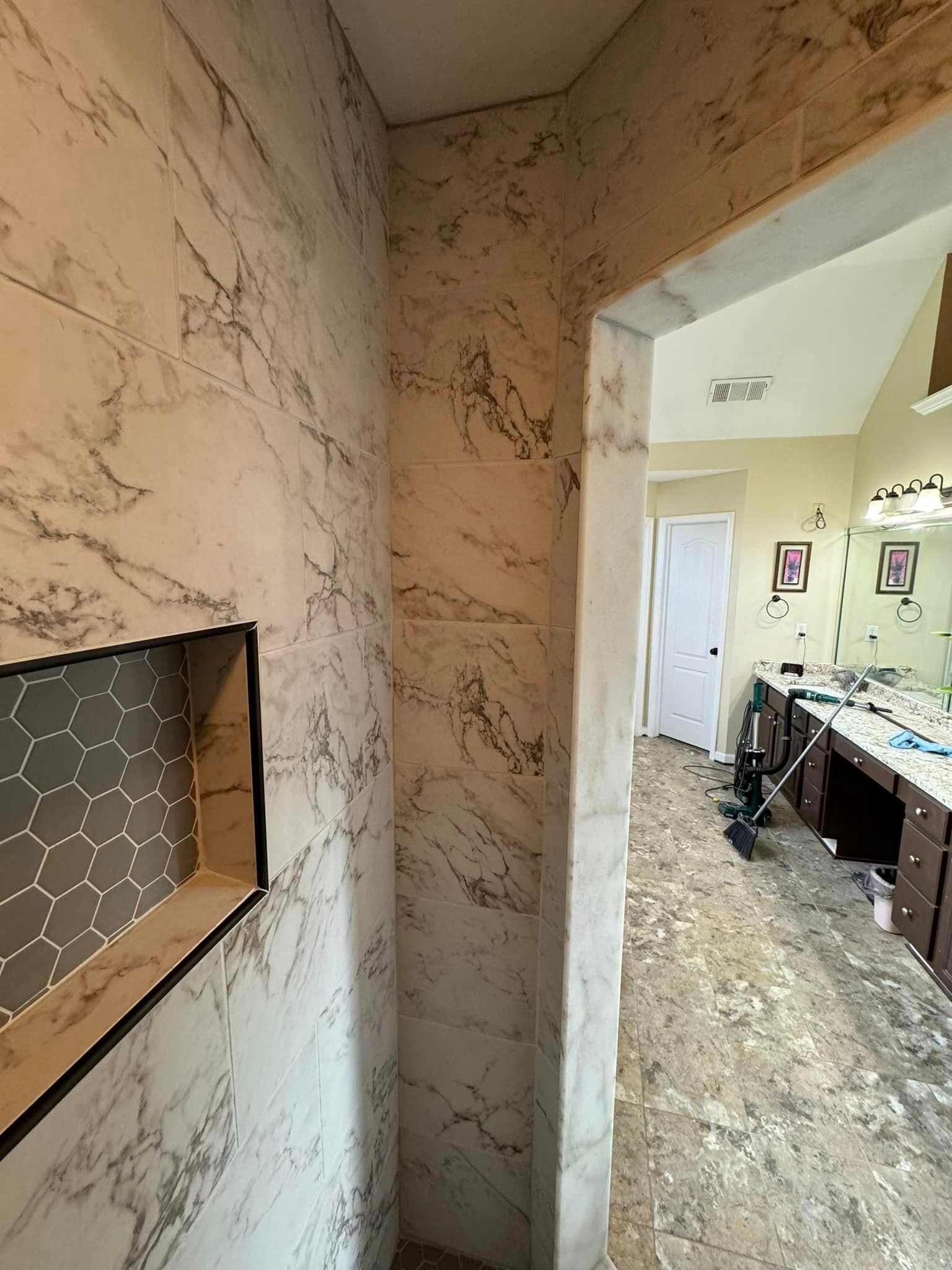 A bathroom with marble walls and a niche in the wall.