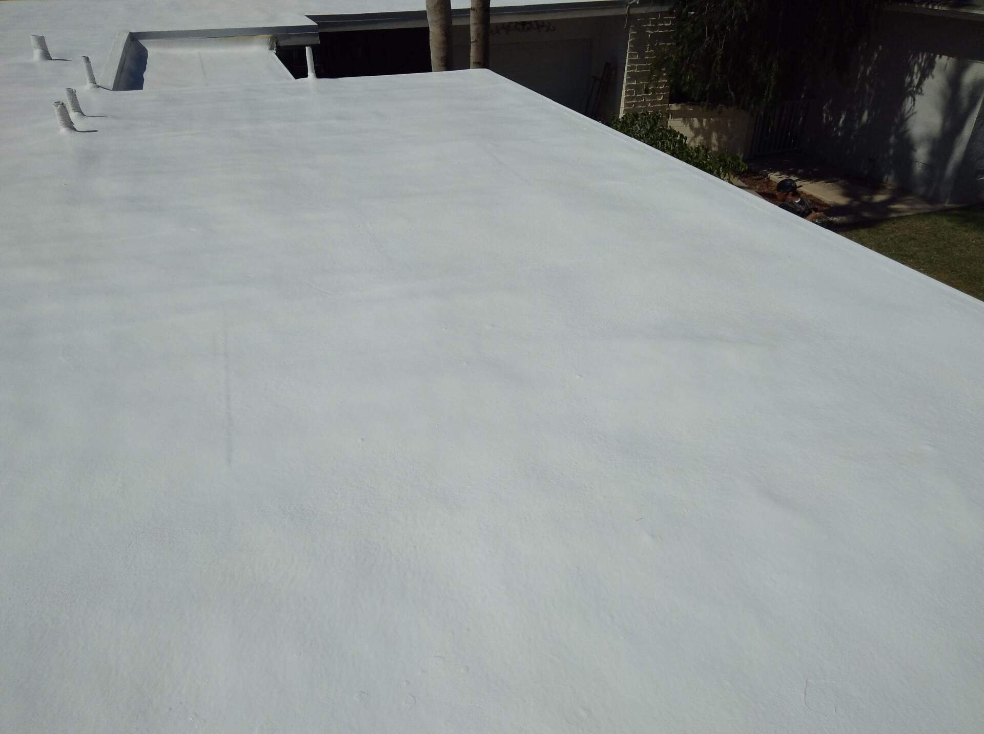 White flat roof on a sunny day, possibly newly painted.