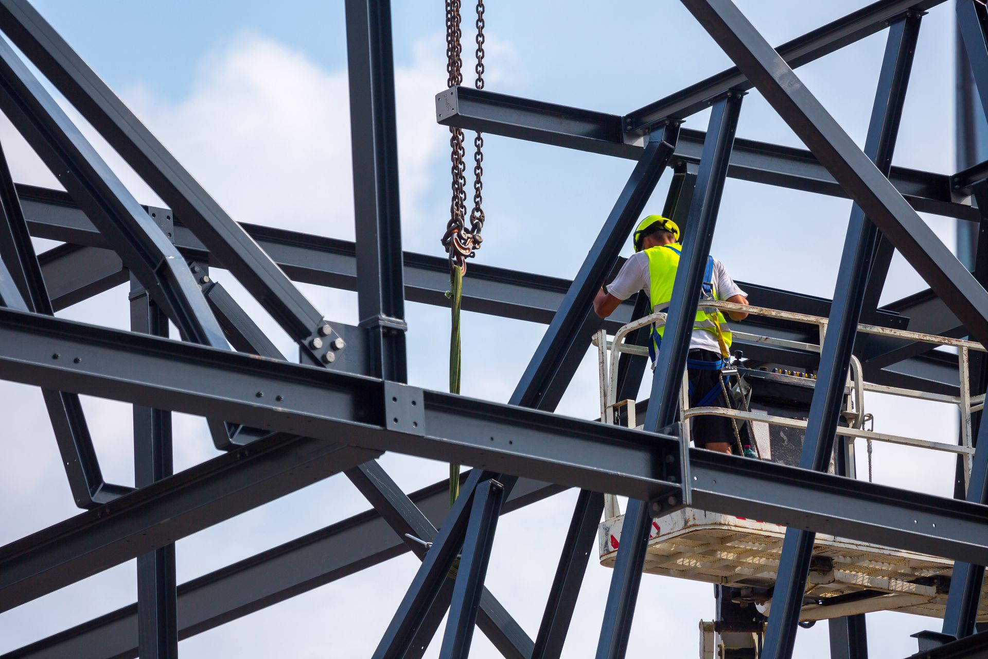 Person in protective suit using a demolition hammer to remove plaster from a wall in a room. Person in protective suit using a demolition hammer to remove plaster from a wall in a room.