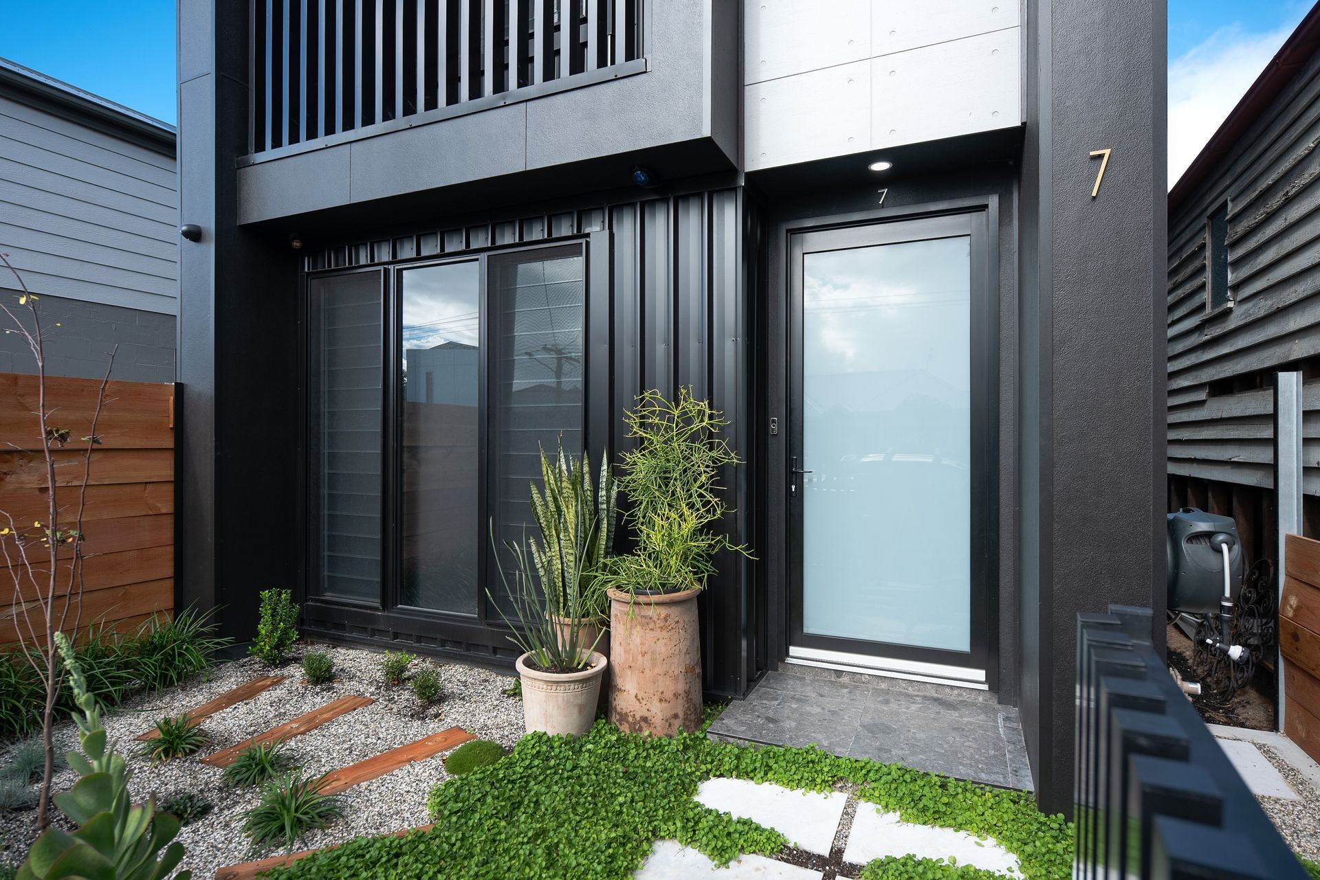 Modern custom home two storey home entrance with landscaped front courtyard by Yarrum Designer Homes.