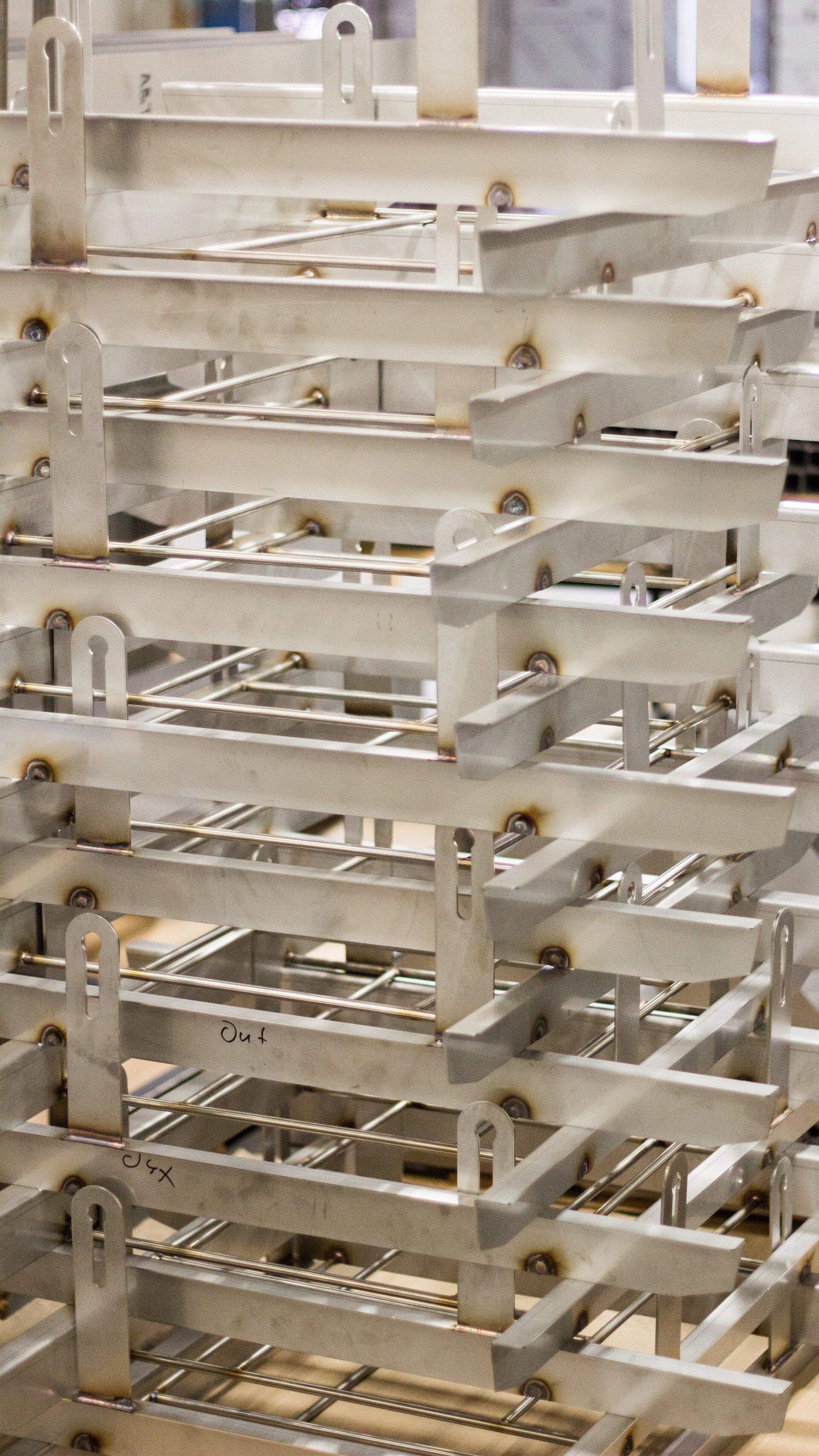 A bunch of fabricated metal frameworks stacked on top of each other in a factory.