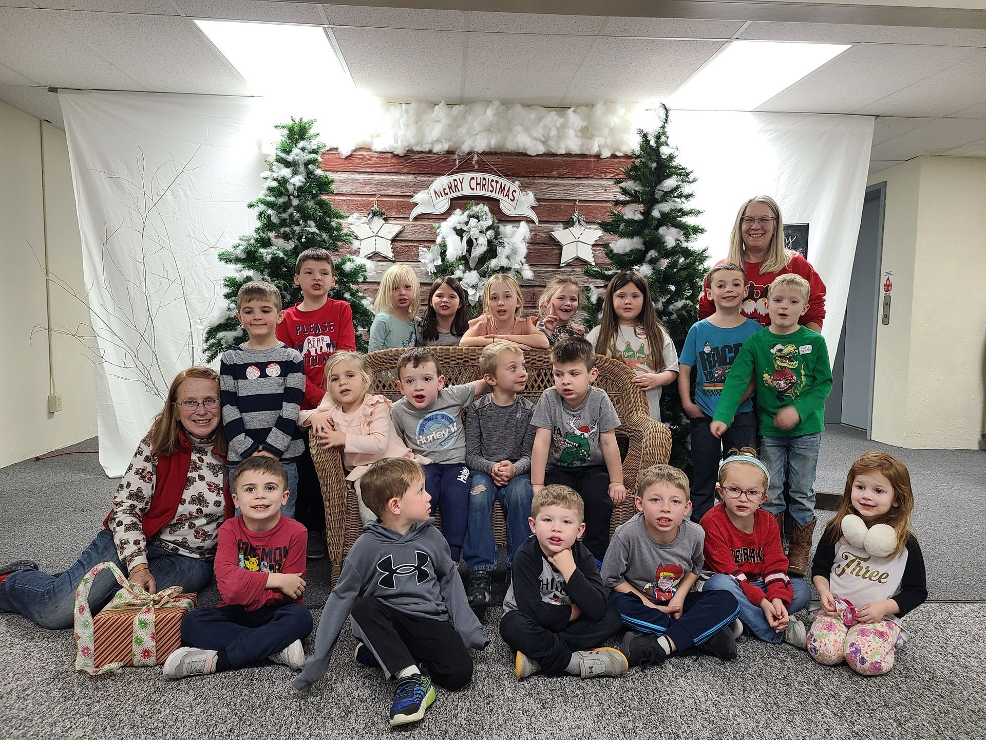 A group of children are posing for a picture in front of a christmas tree during Worship on Wednesday.