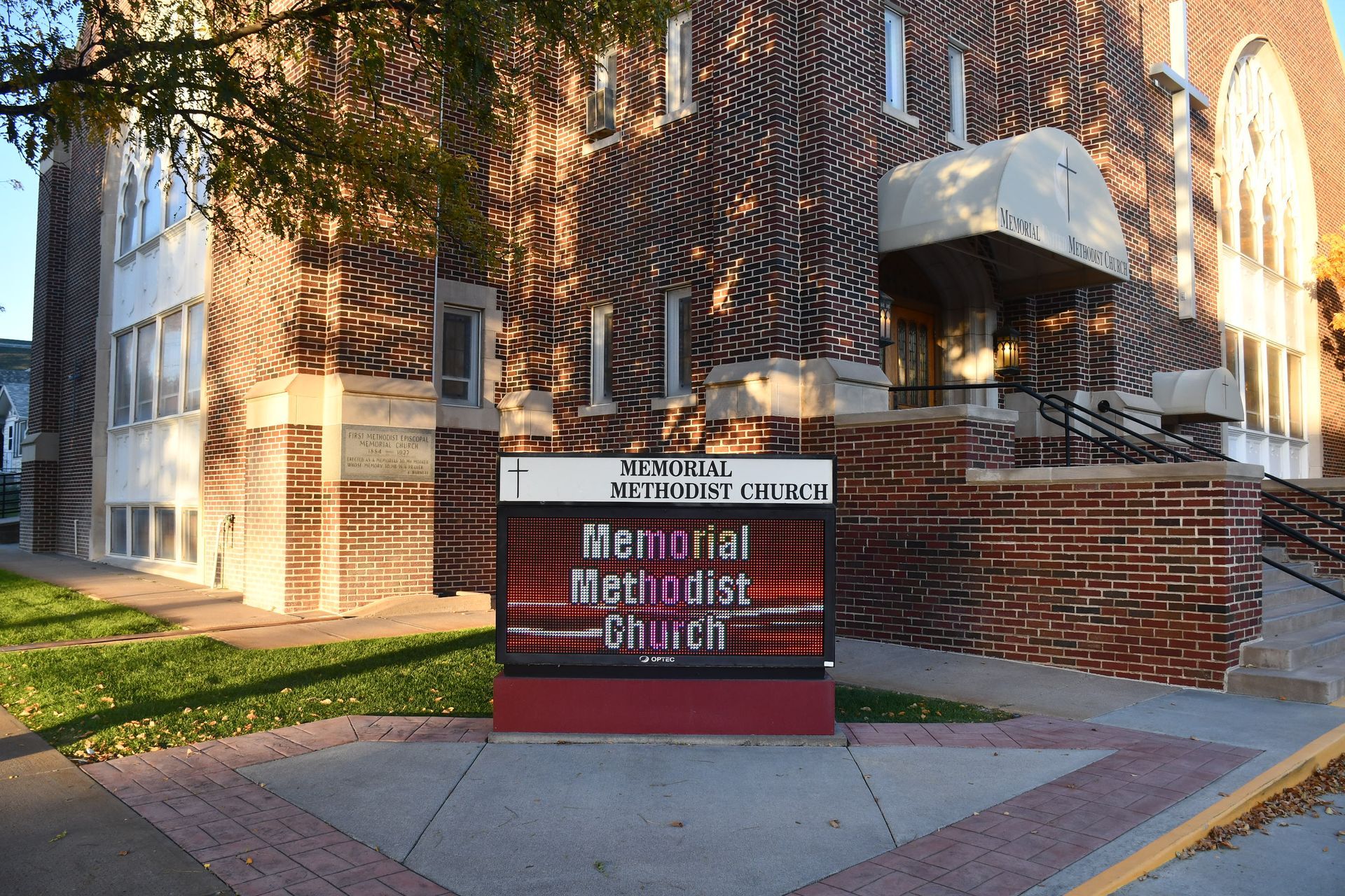 A sign for the Memorial Methodist Church in front of  brick building