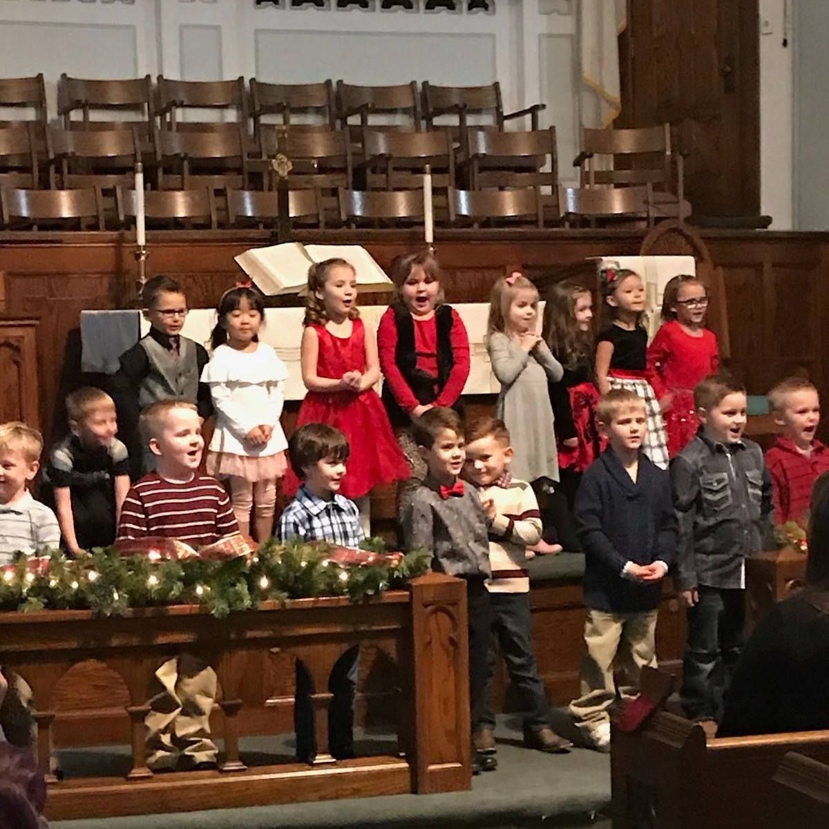 A group of children are singing in a church.