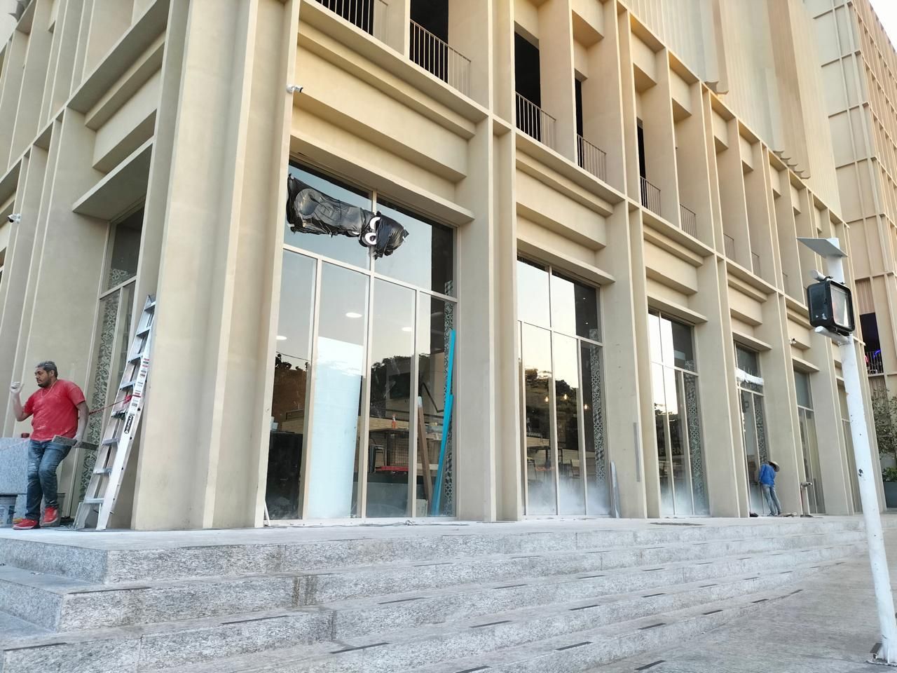 Edificio con ventanas rotas, posibles daños por incendio. Un hombre está cerca.