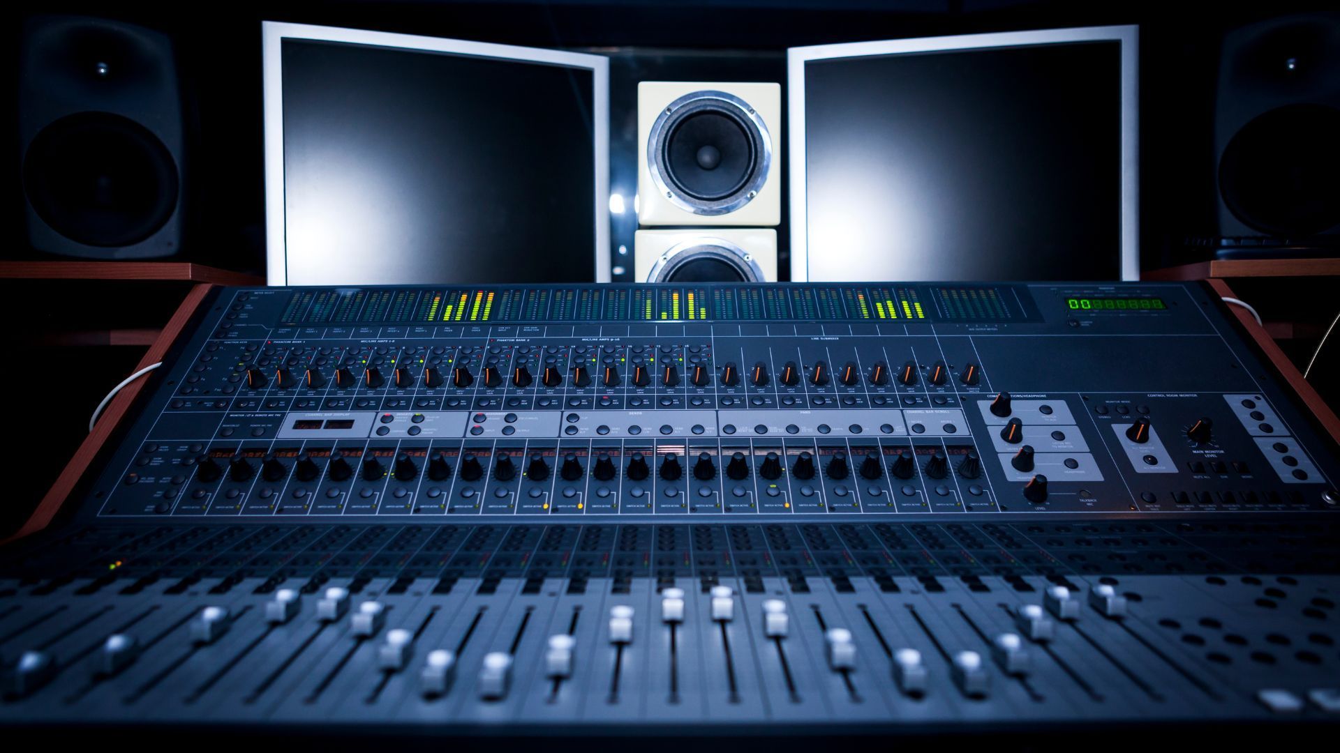 a recording studio with a mixer and two monitors