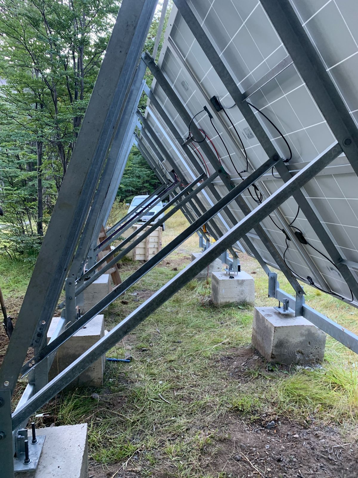 Paneles solares montados sobre marcos metálicos, soportados por bloques de hormigón, en exterior.