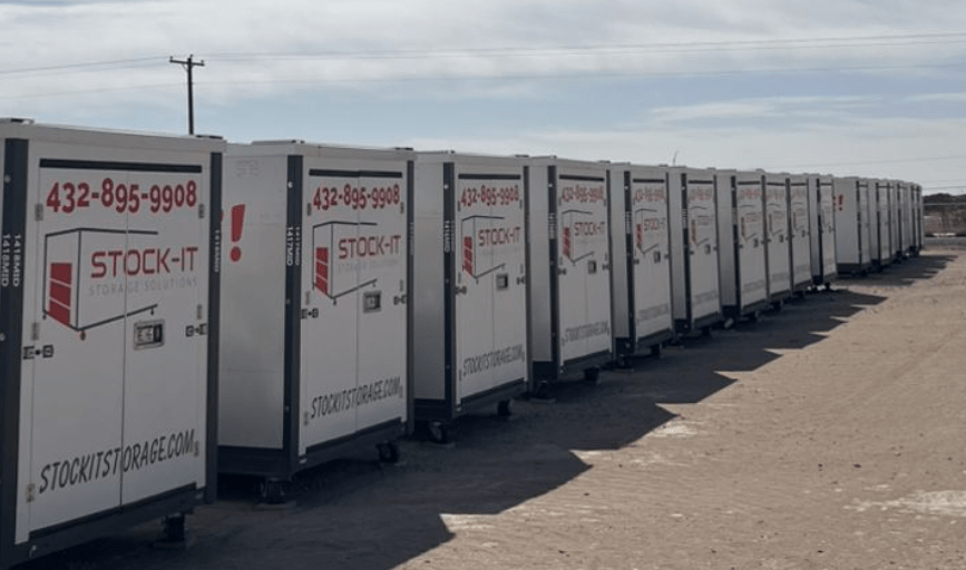A row of storage containers are lined up in a parking lot.
