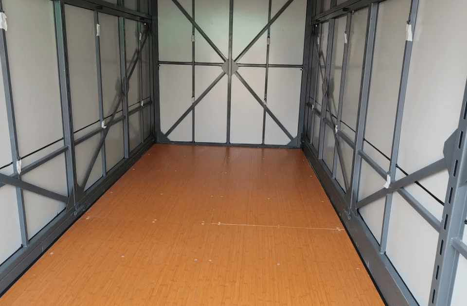 An empty room with a wooden floor and a metal frame.