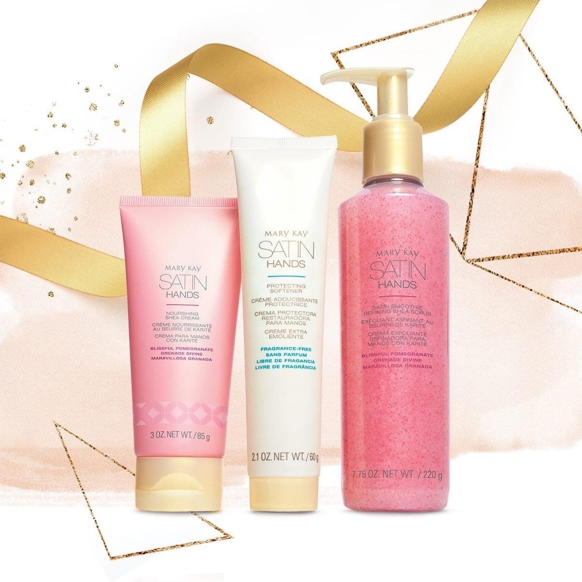Three pink and white skincare products with gold accents, set against a gold ribbon and geometric background.