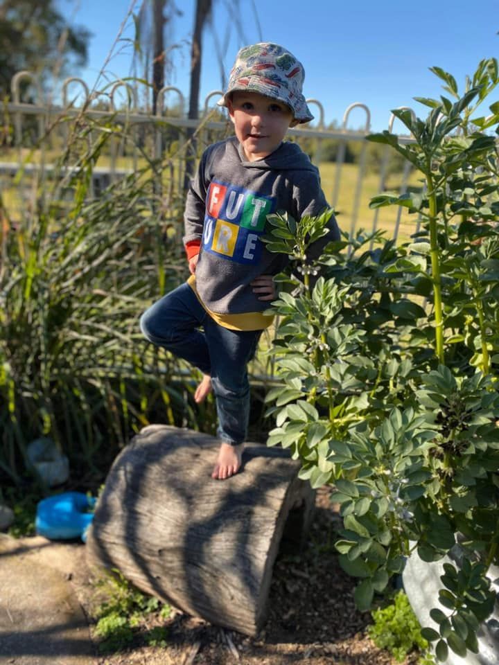 Young child balancing on a log in a garden — Earth Angels Child Care Centre in Tinonee, NSW