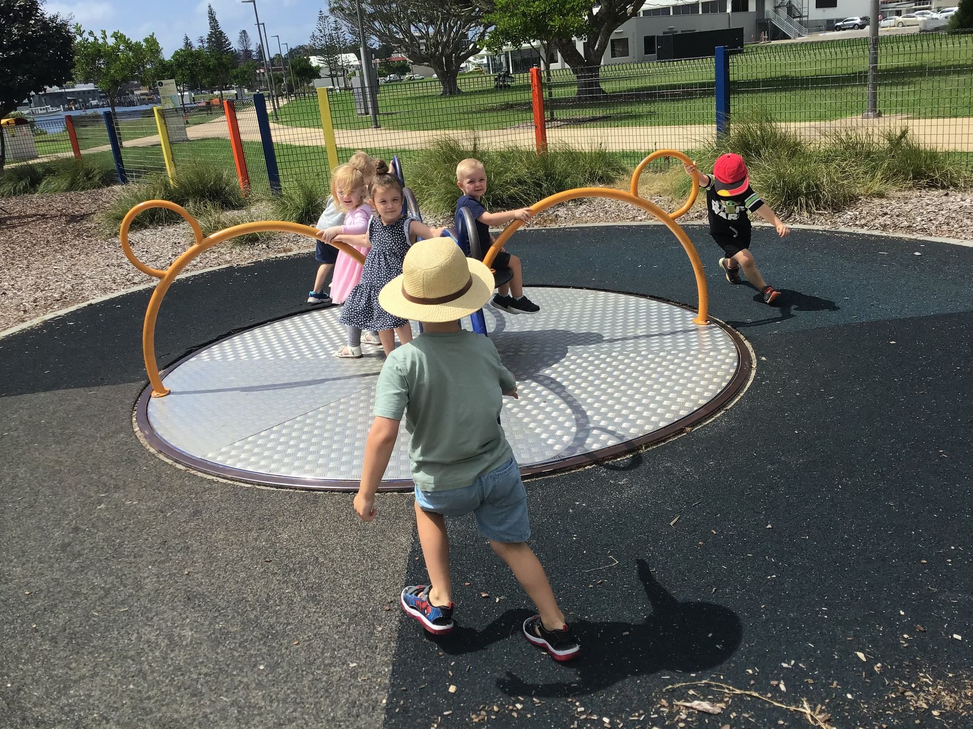 Children playing on a merry-go-round in a park. — Earth Angels Child Care Centre in Tinonee, NSW