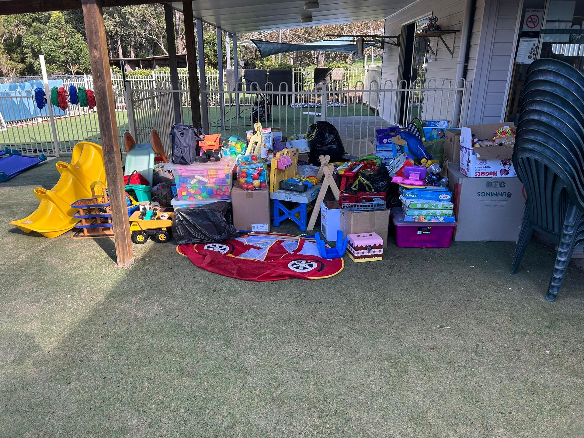 A Bunch of Toys Are Sitting on the Grass Under a Covered Area — Earth Angels Child Care Centre in Tinonee, NSW