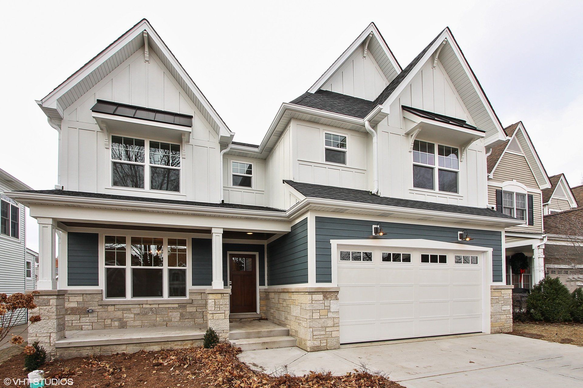 A large white house with blue siding and a white garage door