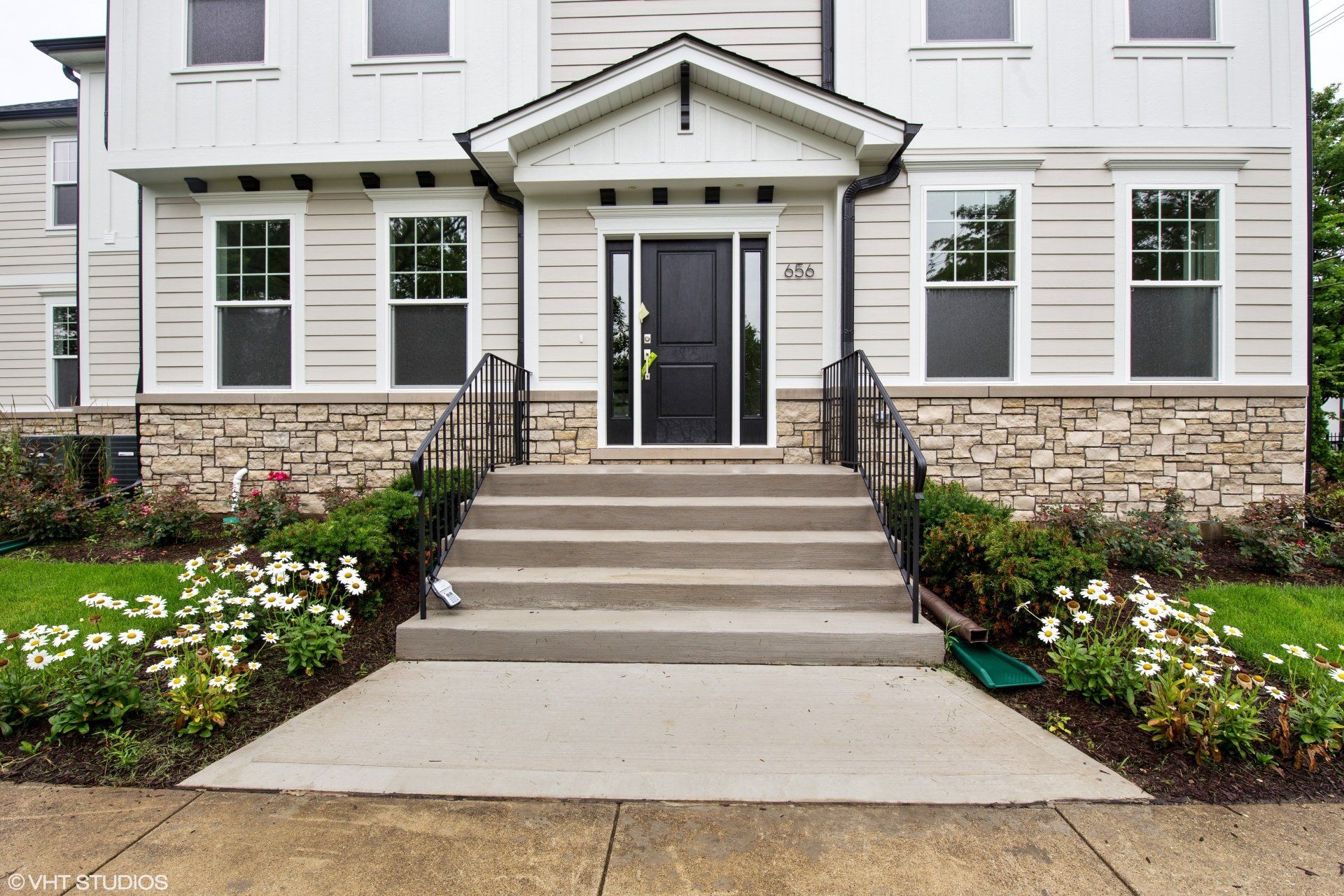 A white house with a black door and steps