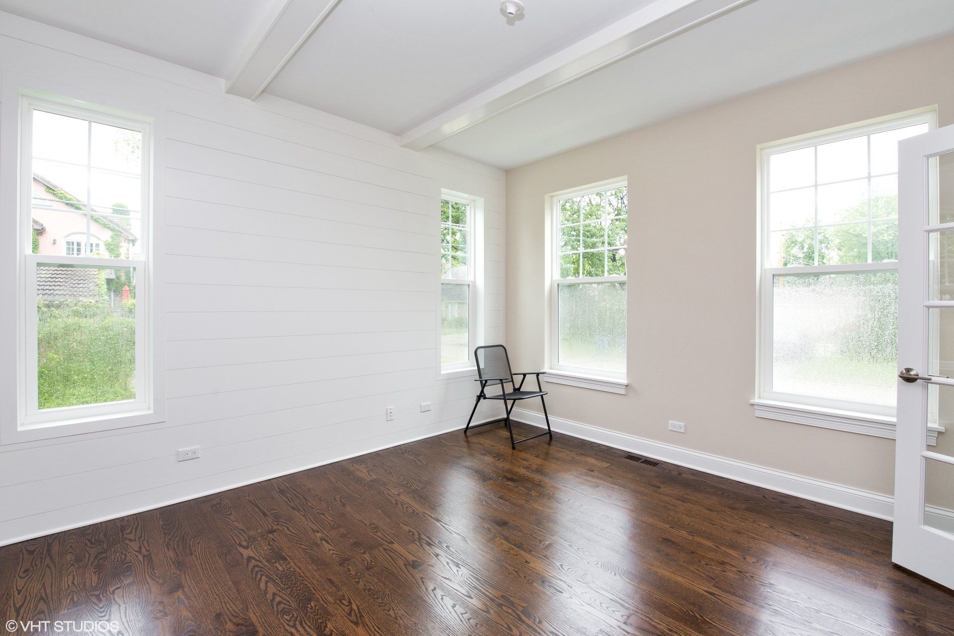 An empty room with hardwood floors and white walls.