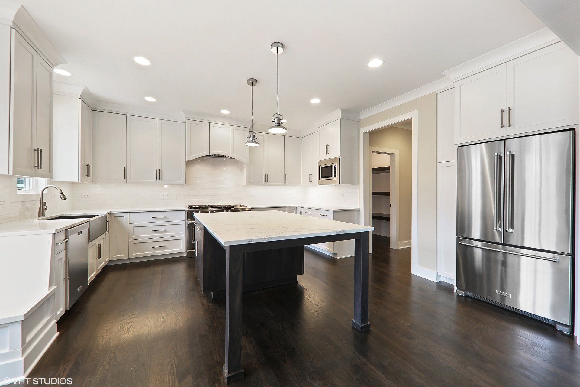 A kitchen with white cabinets and stainless steel appliances