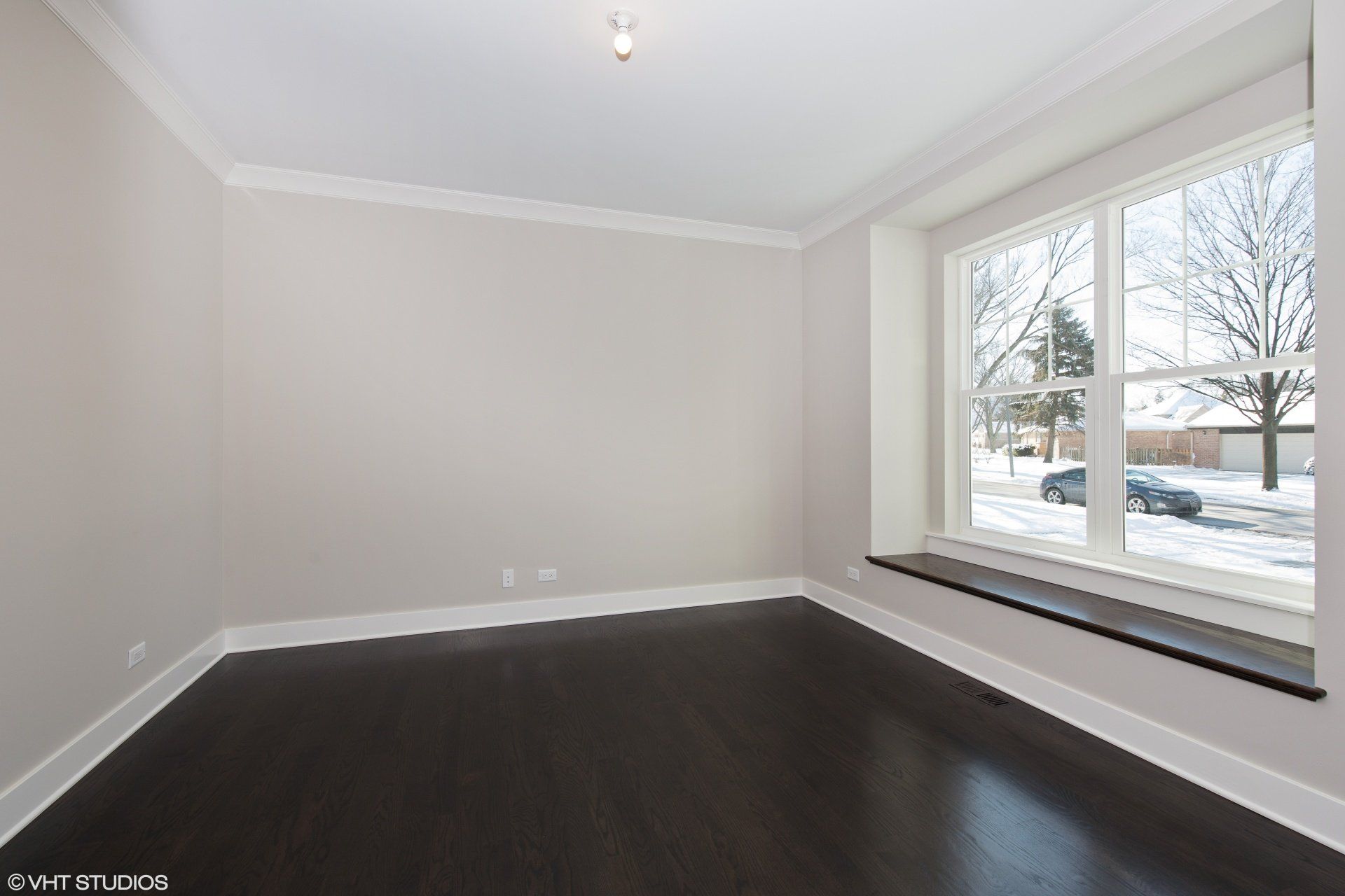 An empty room with a large window and a bench