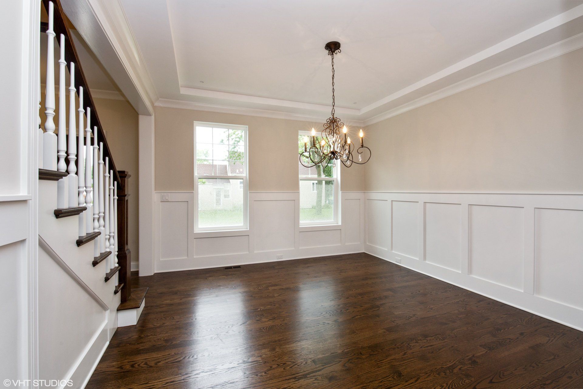 An empty dining room with stairs and a chandelier