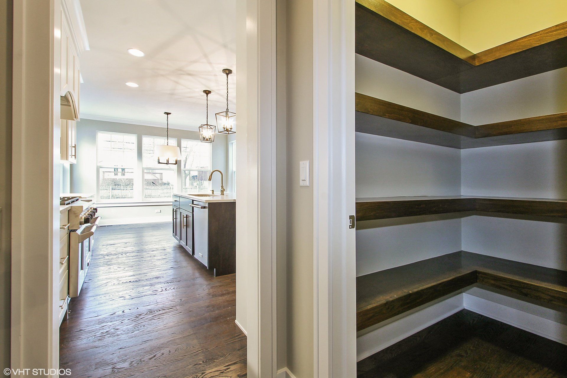 A walk in pantry in a kitchen next to a kitchen.