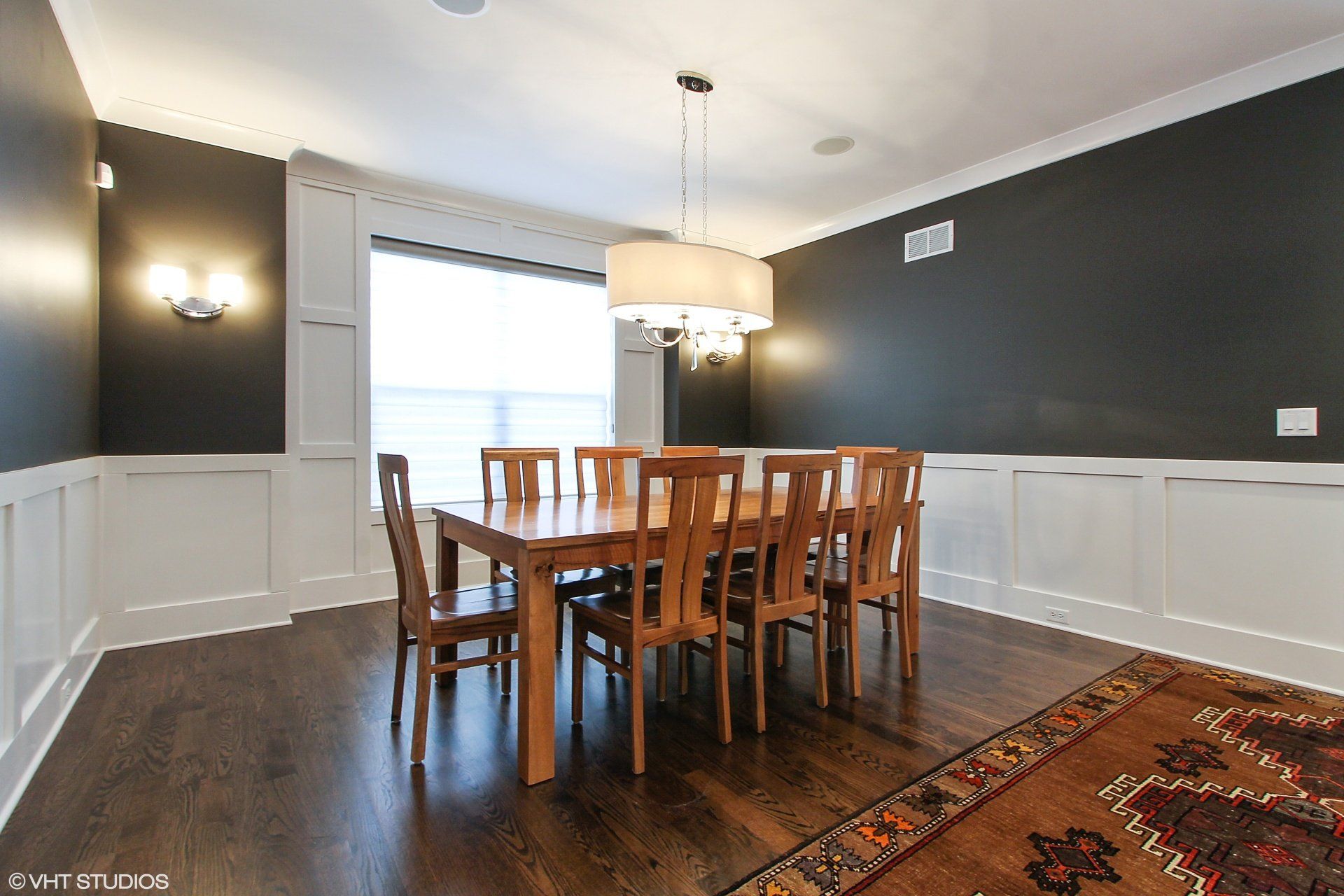 A dining room with a table and chairs and a rug