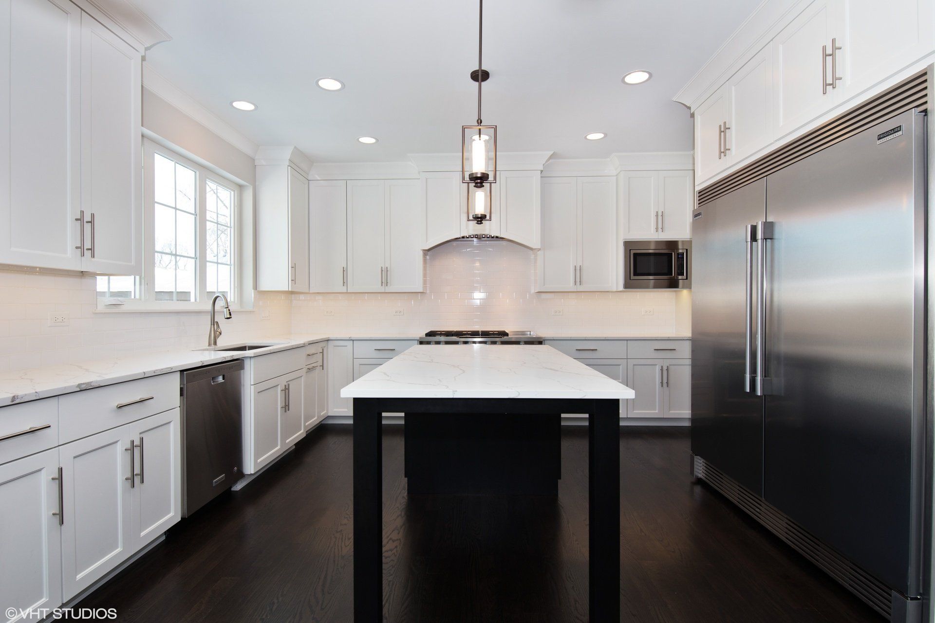 A kitchen with white cabinets and stainless steel appliances