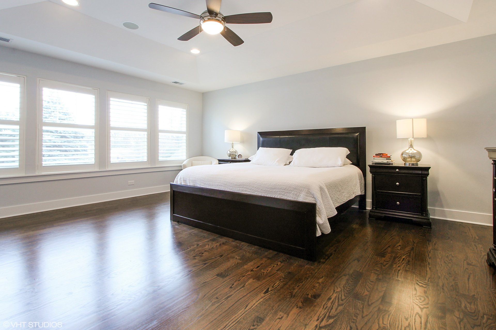 A bedroom with a large bed and a ceiling fan