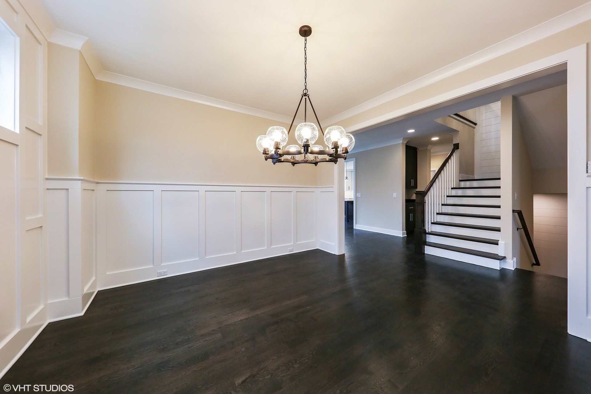 An empty room with a chandelier hanging from the ceiling