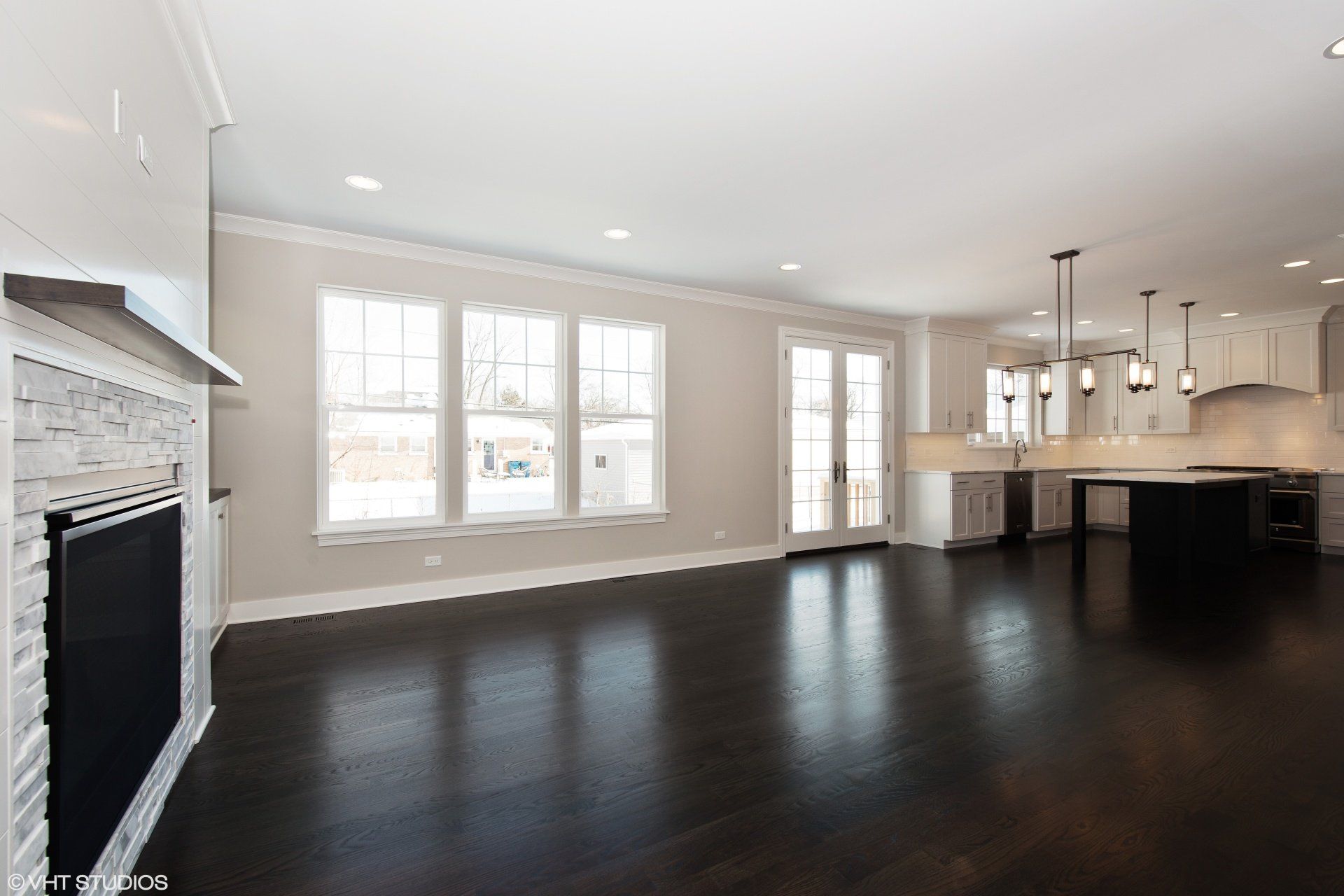 An empty living room with hardwood floors and a fireplace.