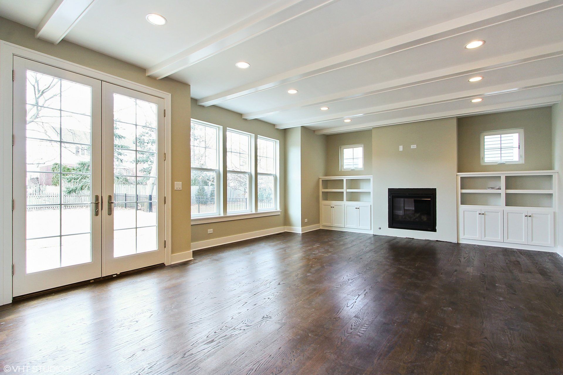 An empty living room with hardwood floors and a fireplace