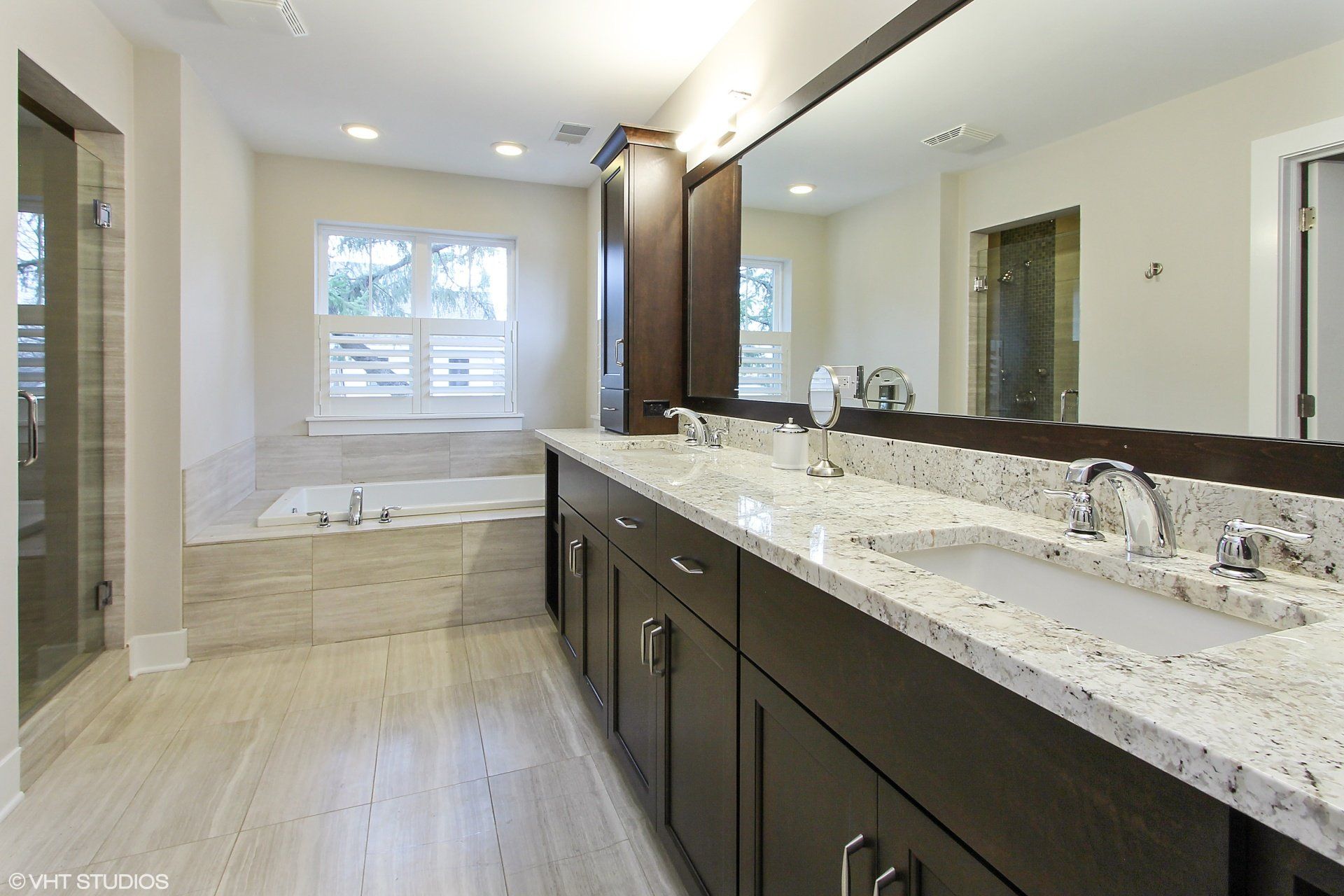 A bathroom with two sinks and a large mirror