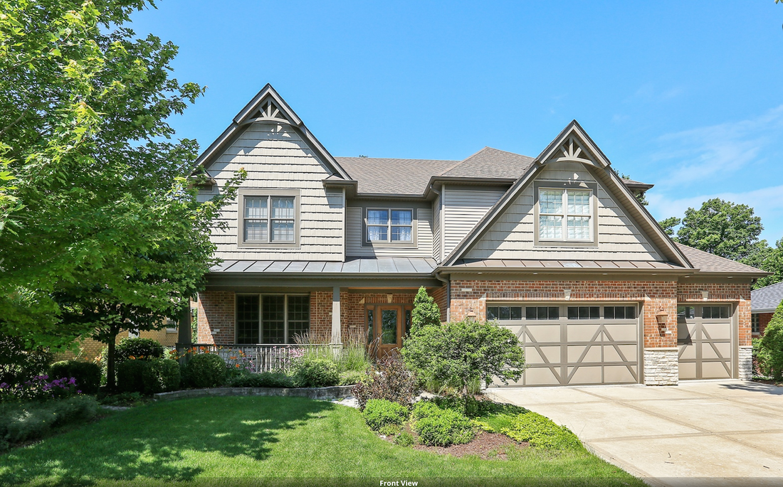 A large house with a lot of windows and a large driveway.