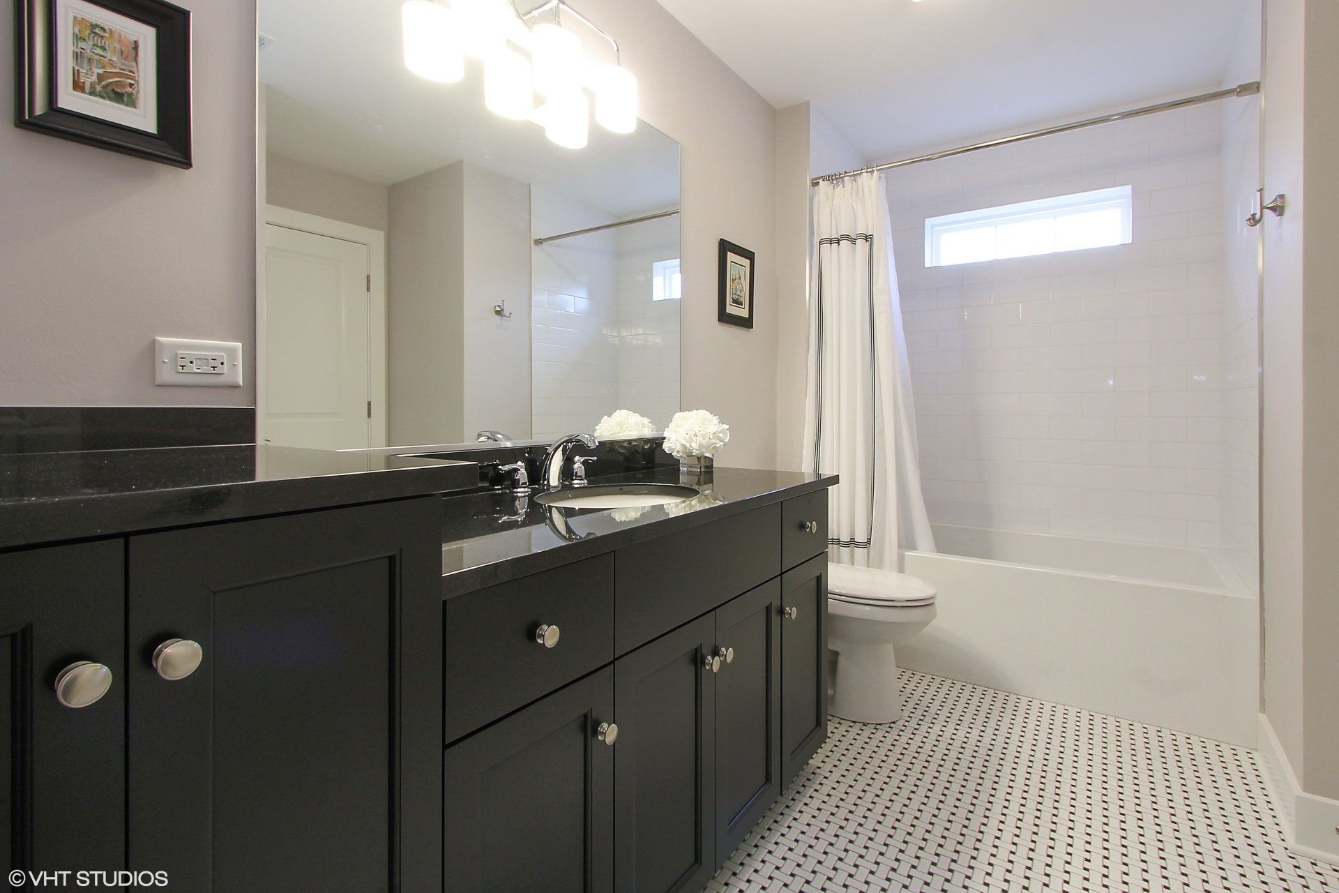 A bathroom with two sinks , a toilet , and a shower.