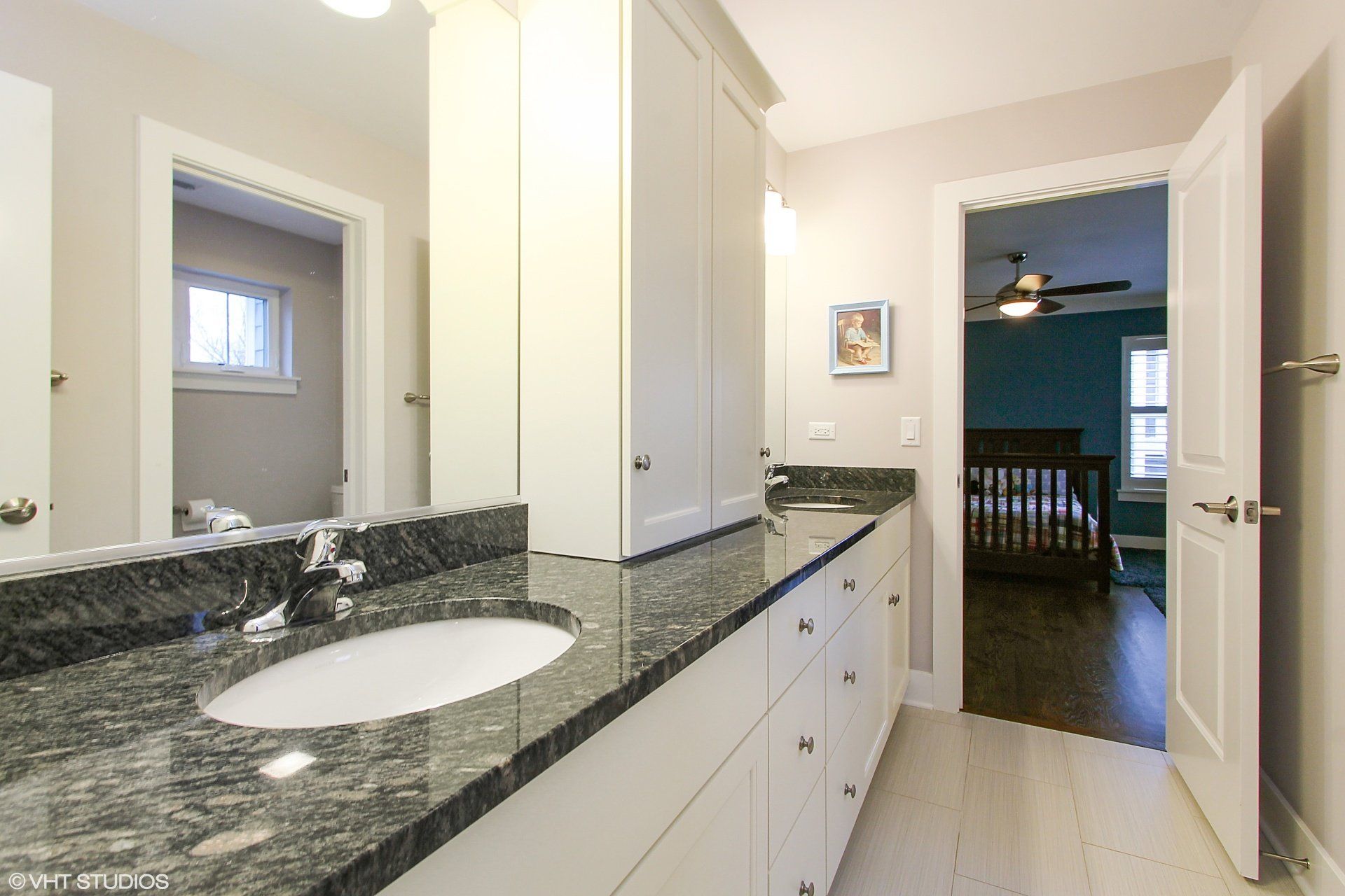 A bathroom with two sinks and a ceiling fan