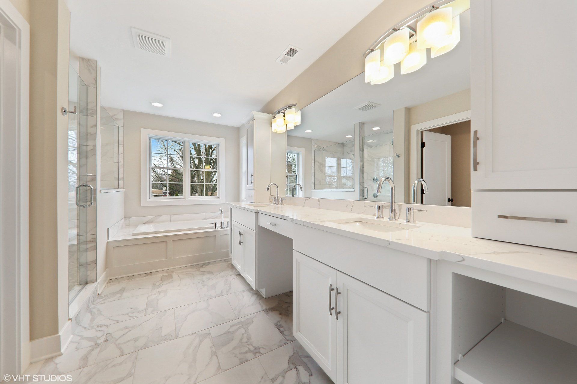 A bathroom with two sinks and a large mirror.