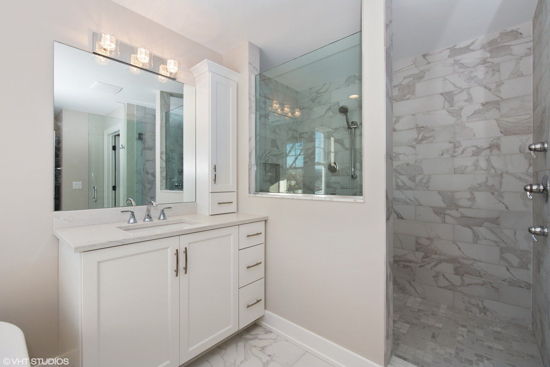 A bathroom with two sinks and a walk in shower.