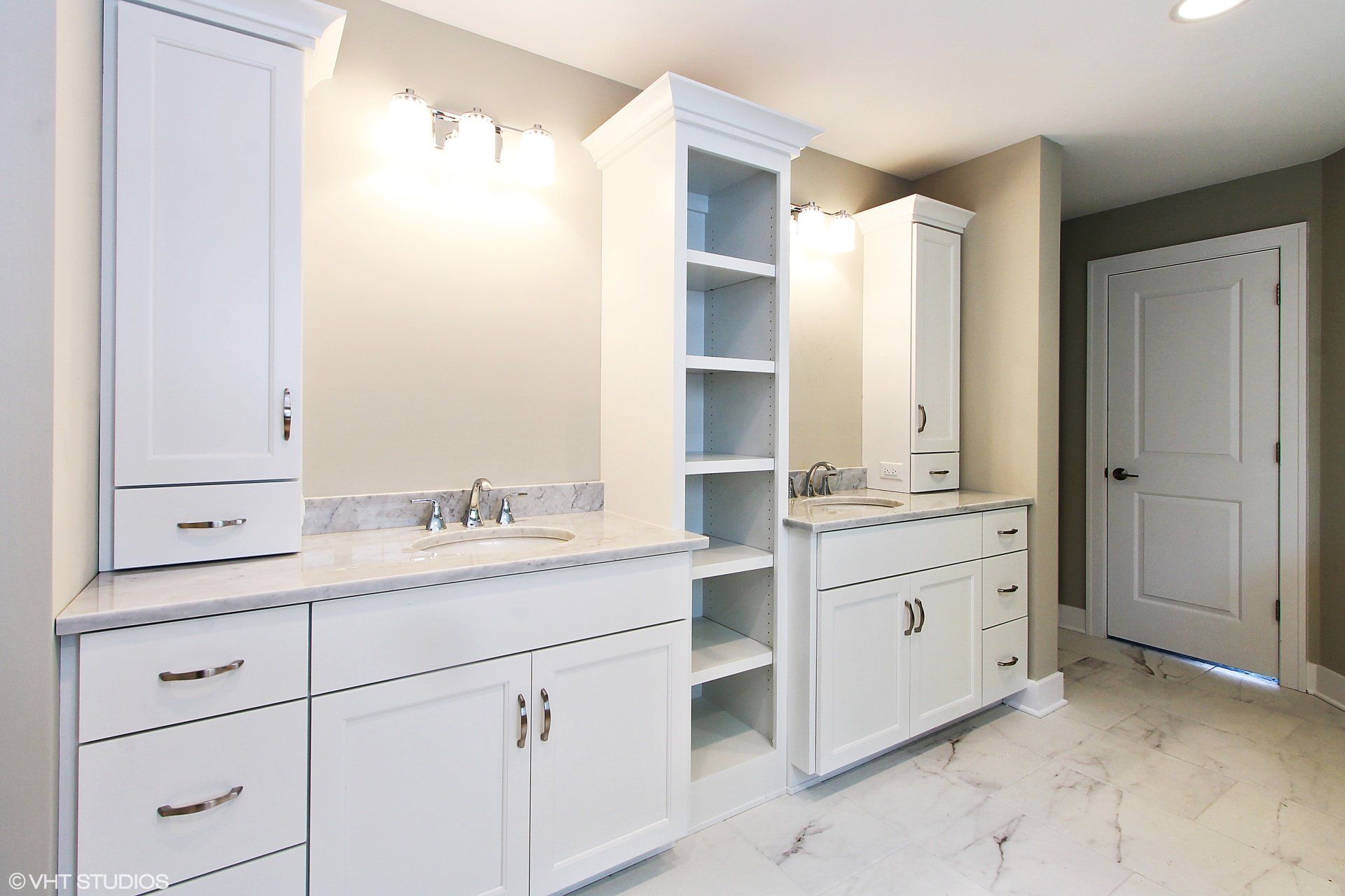A bathroom with white cabinets and marble floors