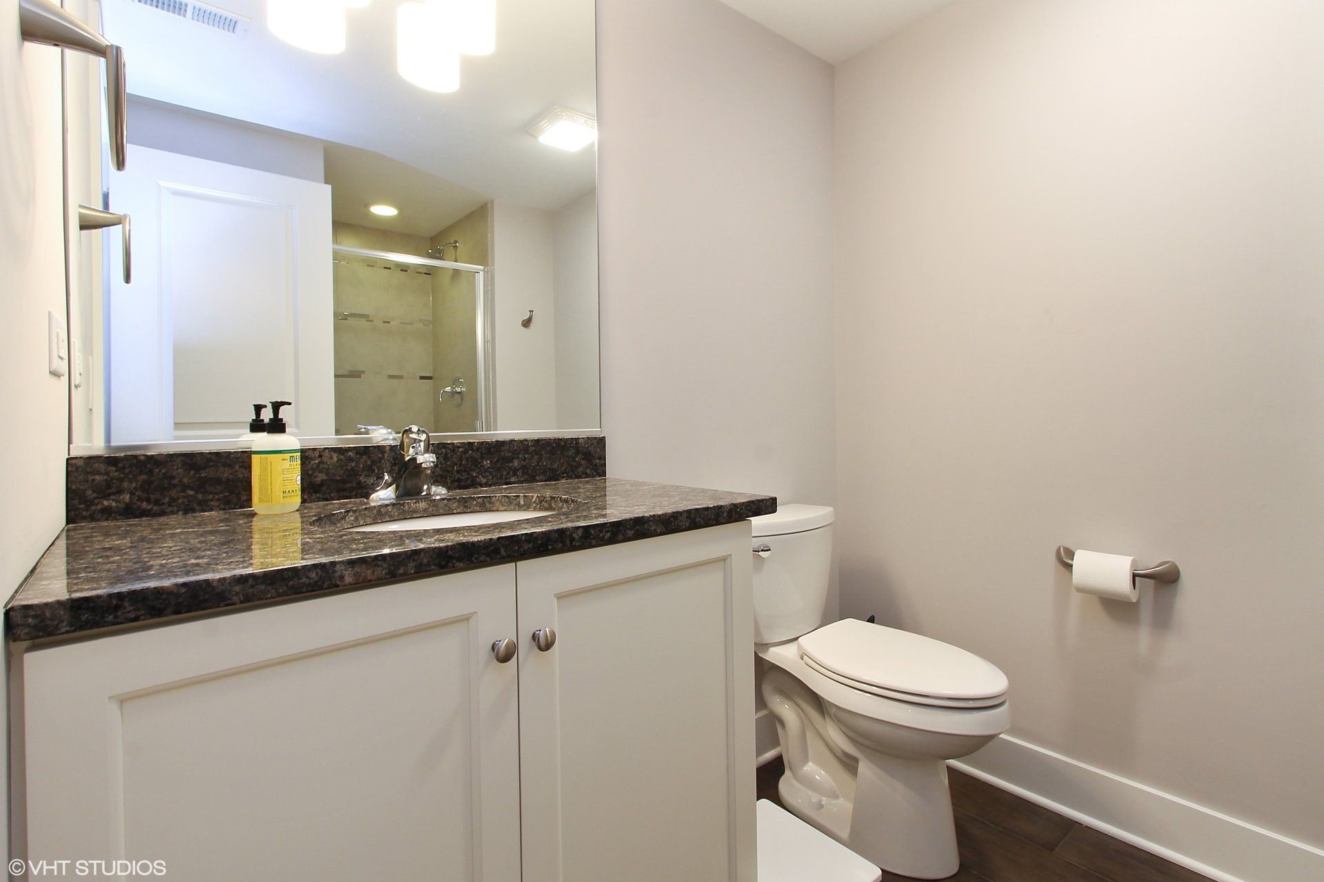 A bathroom with a toilet , sink and mirror