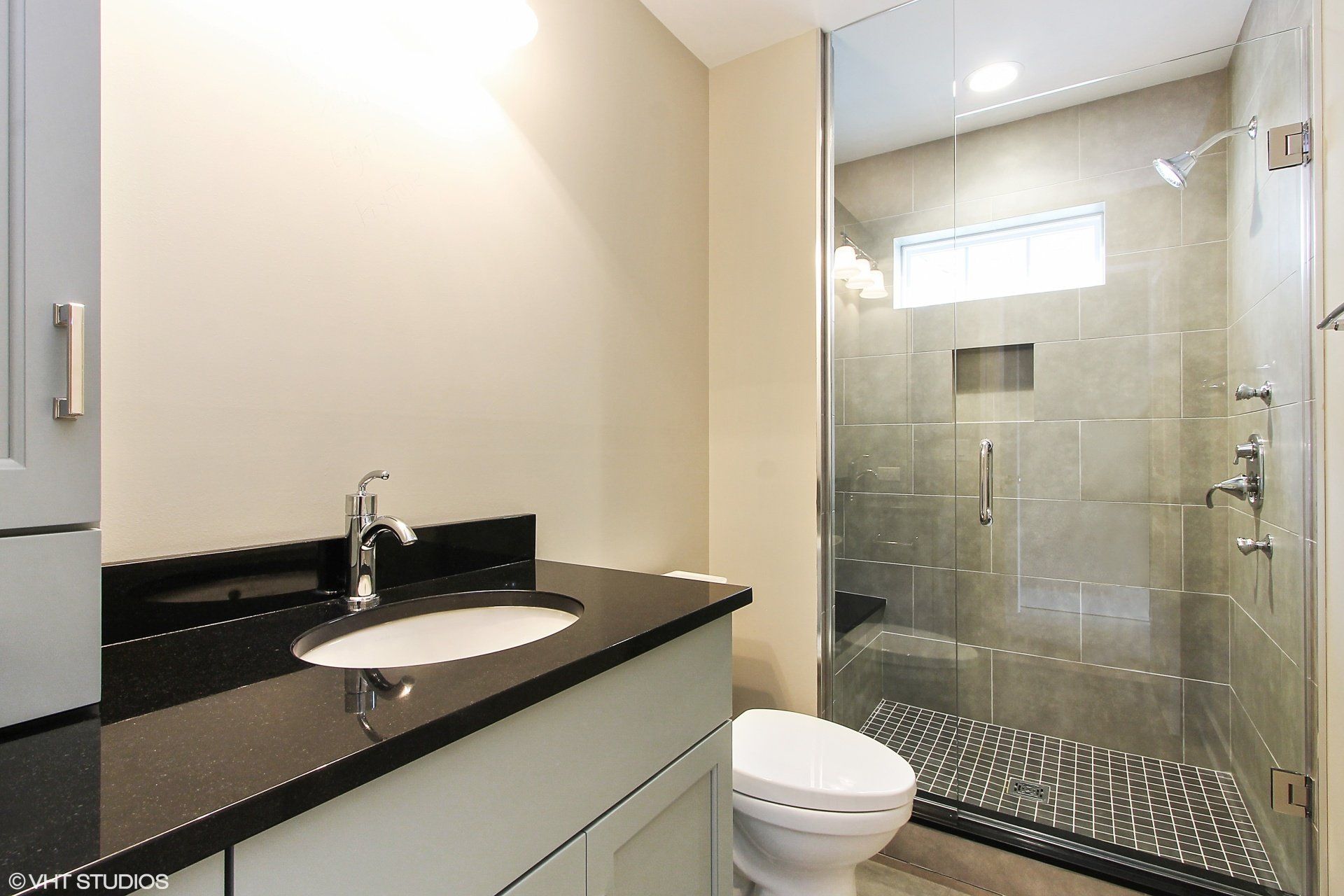 A bathroom with a toilet a sink and a walk in shower