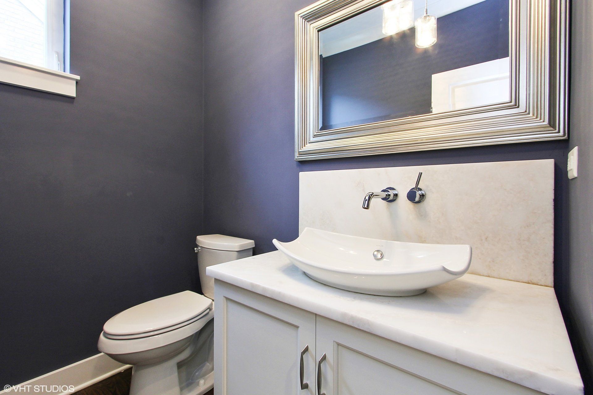 A bathroom with a toilet a sink and a mirror