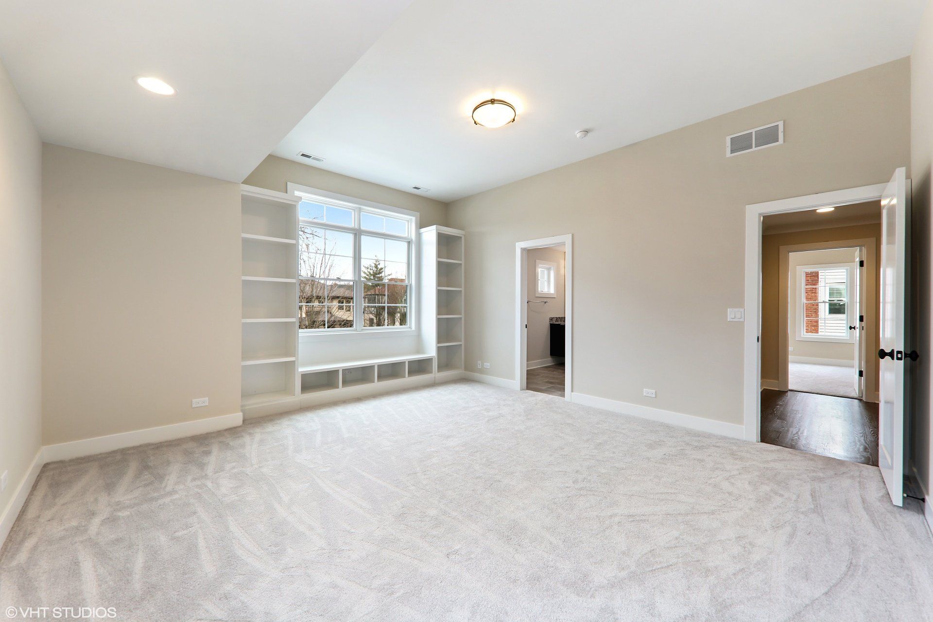 A large empty room with a lot of shelves and a window.