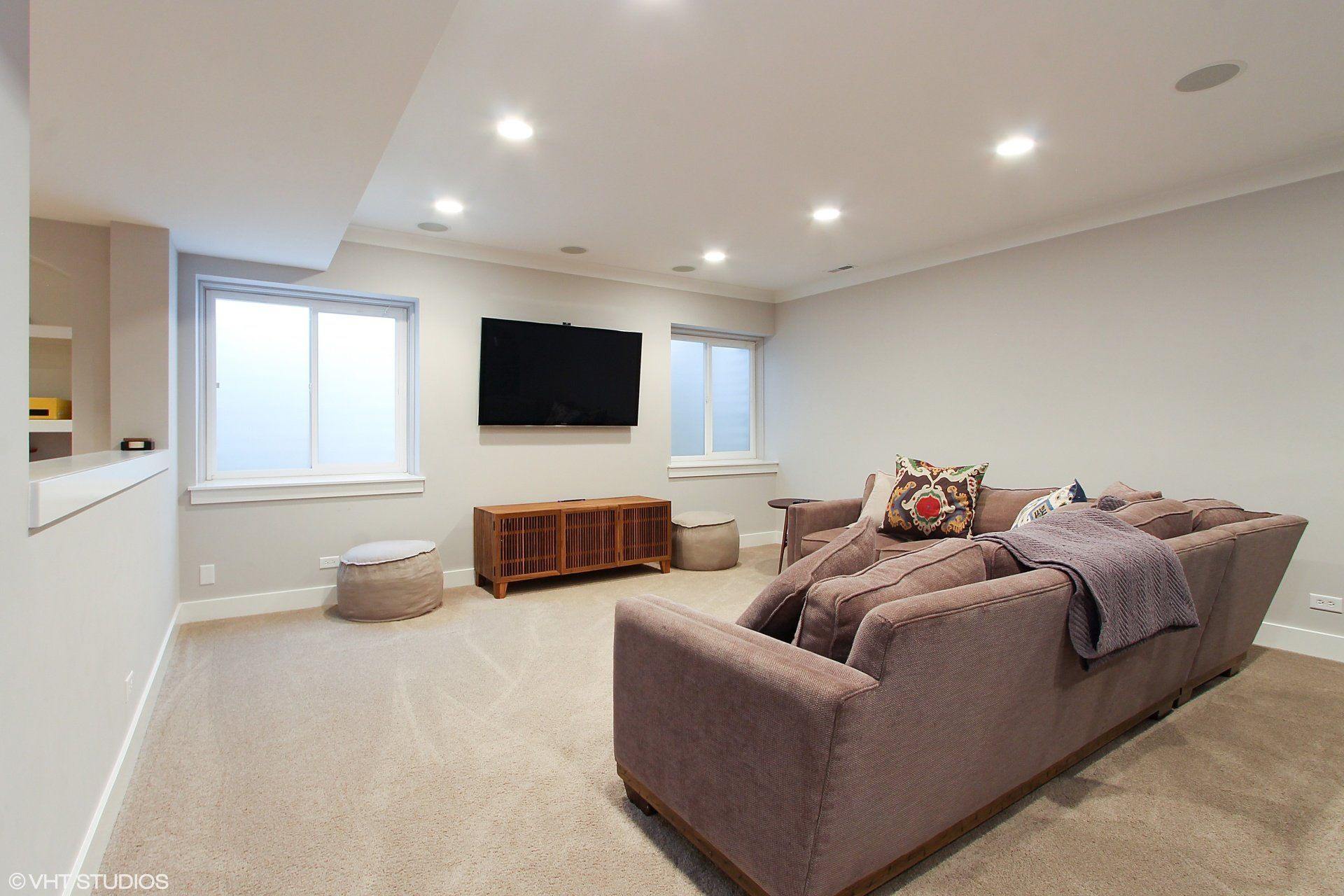 A living room with a couch and a flat screen tv on the wall.