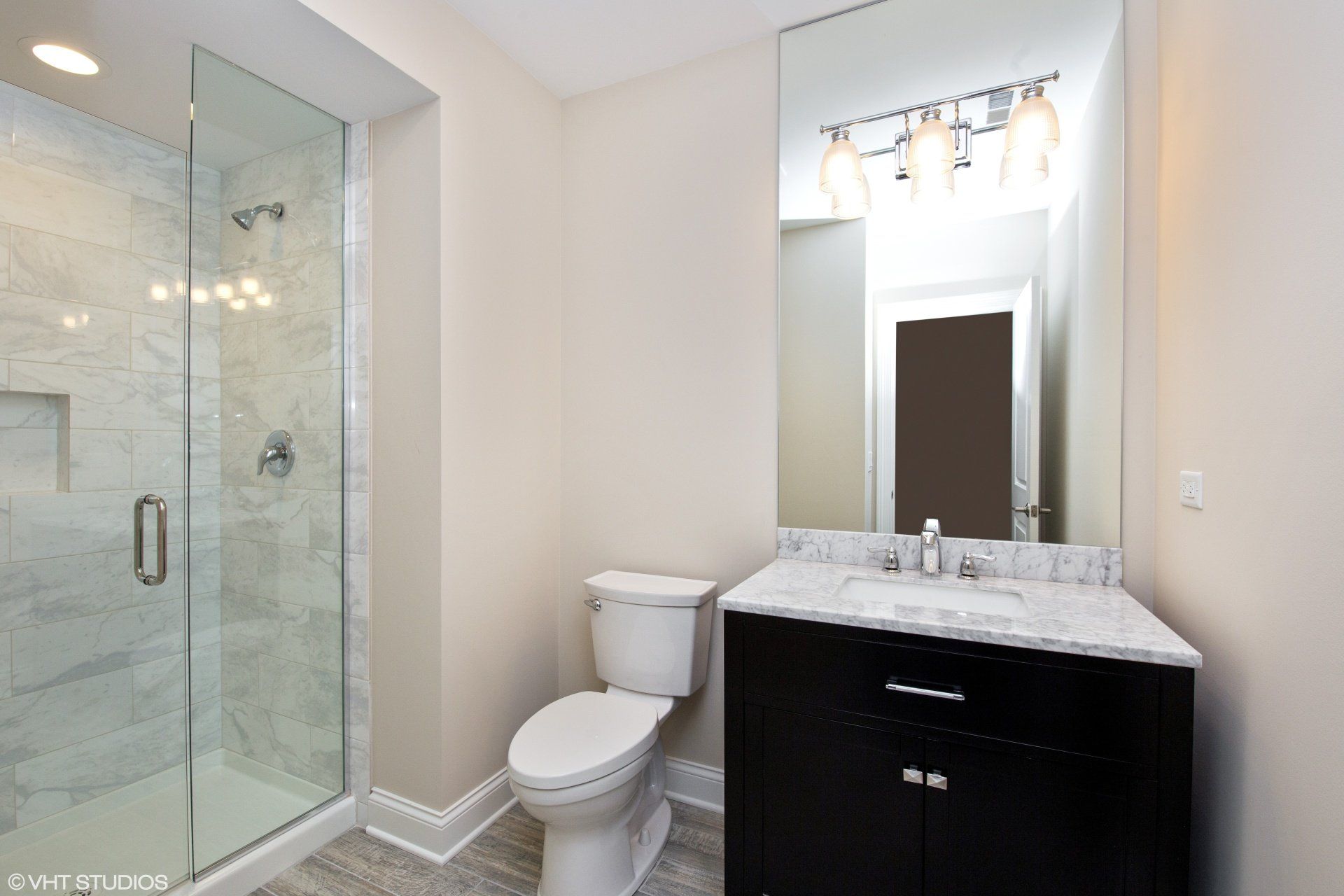 A bathroom with a toilet a sink and a walk in shower